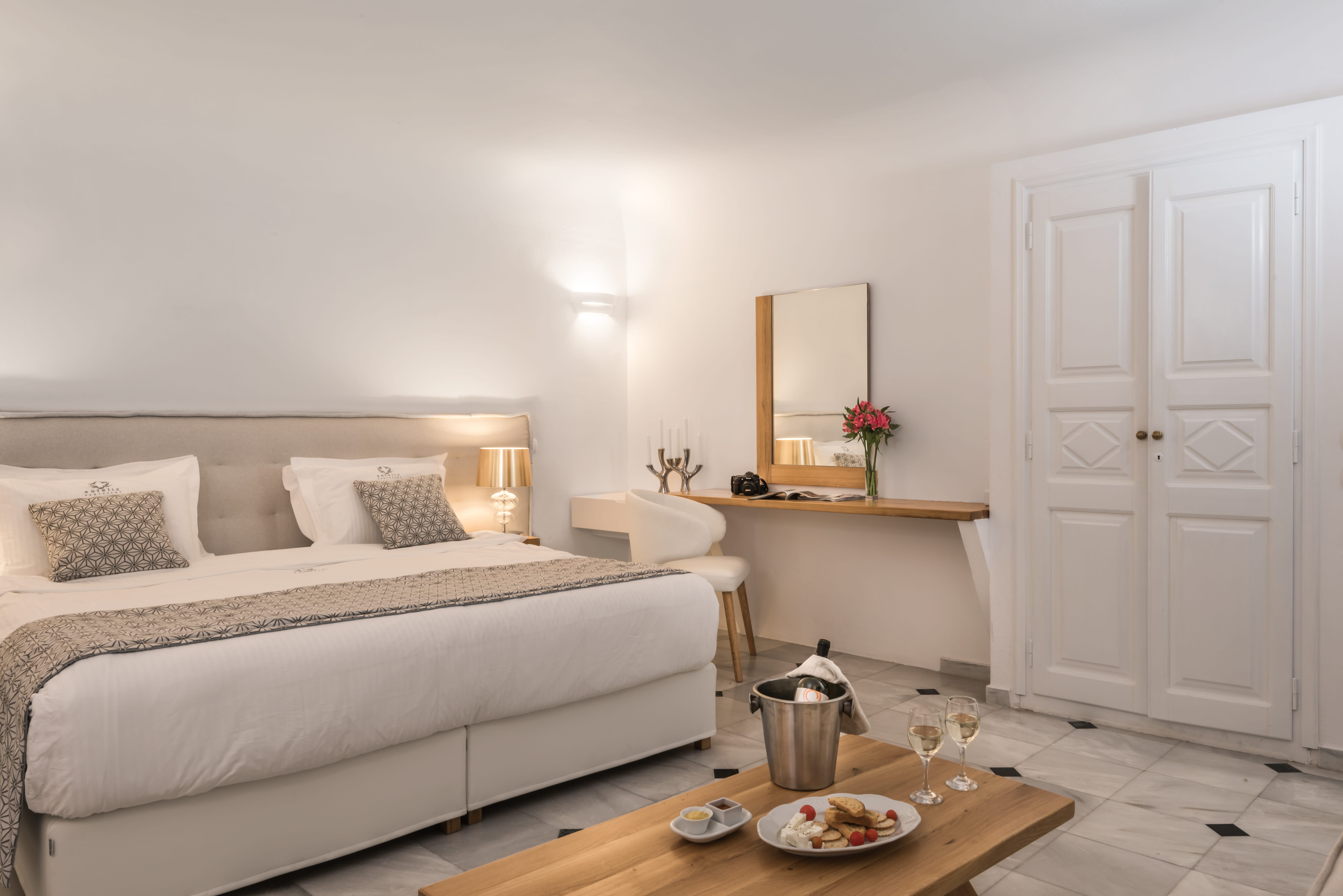 Double room interior with traditional Santorini whitewashed walls and modern furnishings, Anteliz Suites