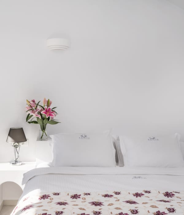 a bed with a white bed and a white wall