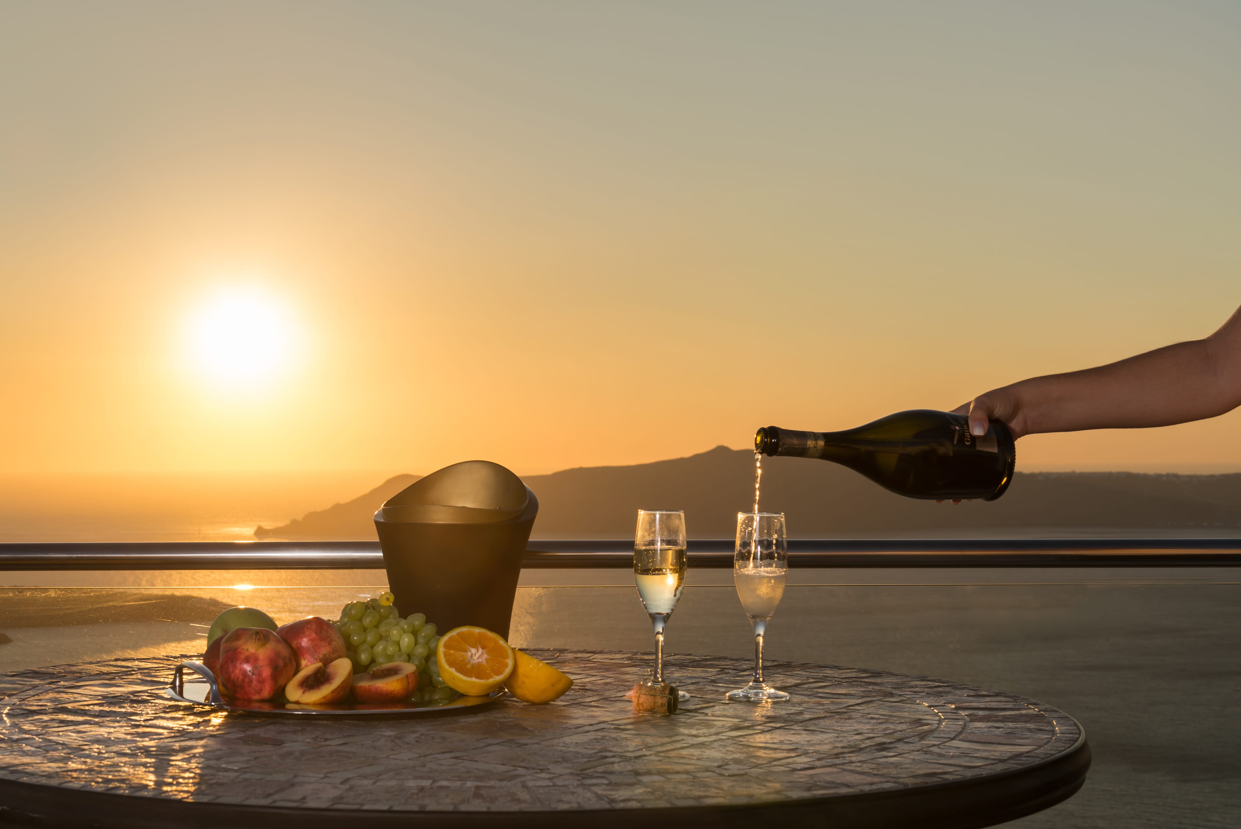a hand pouring wine into glasses