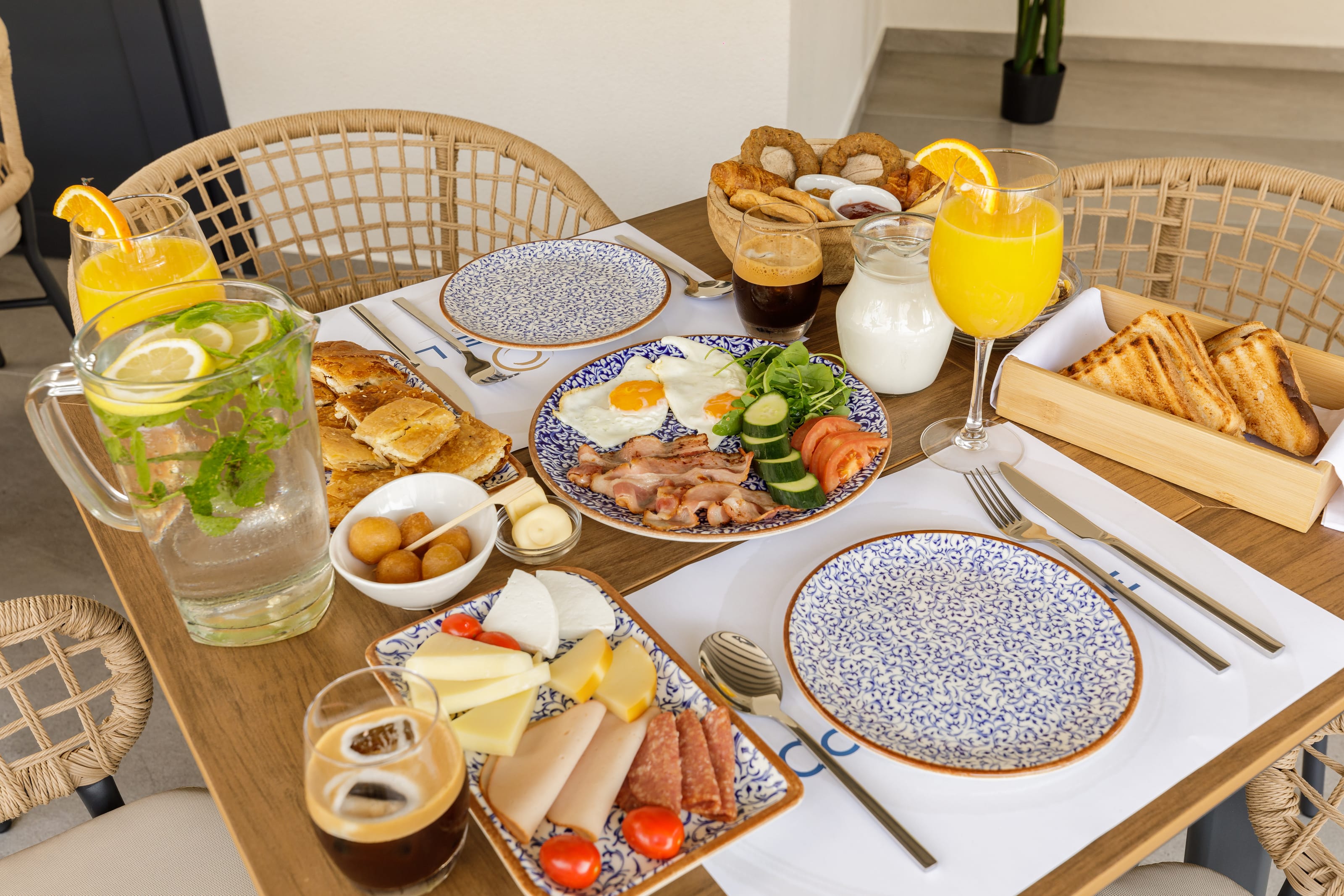 a table with plates of food and glasses of juice