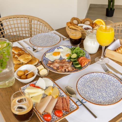a table with plates of food and glasses of juice