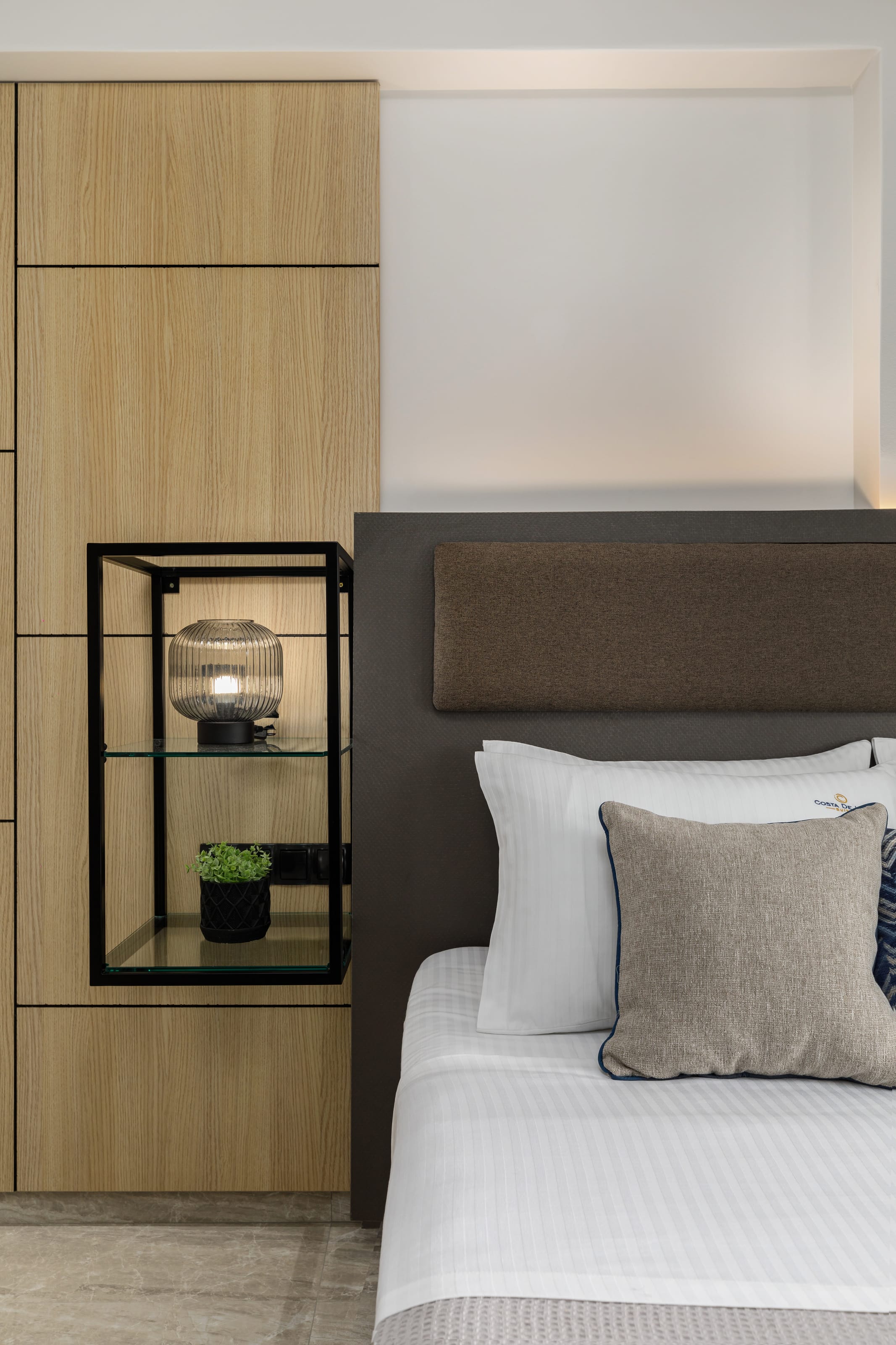 a bed with a glass shelf and a glass coffee table