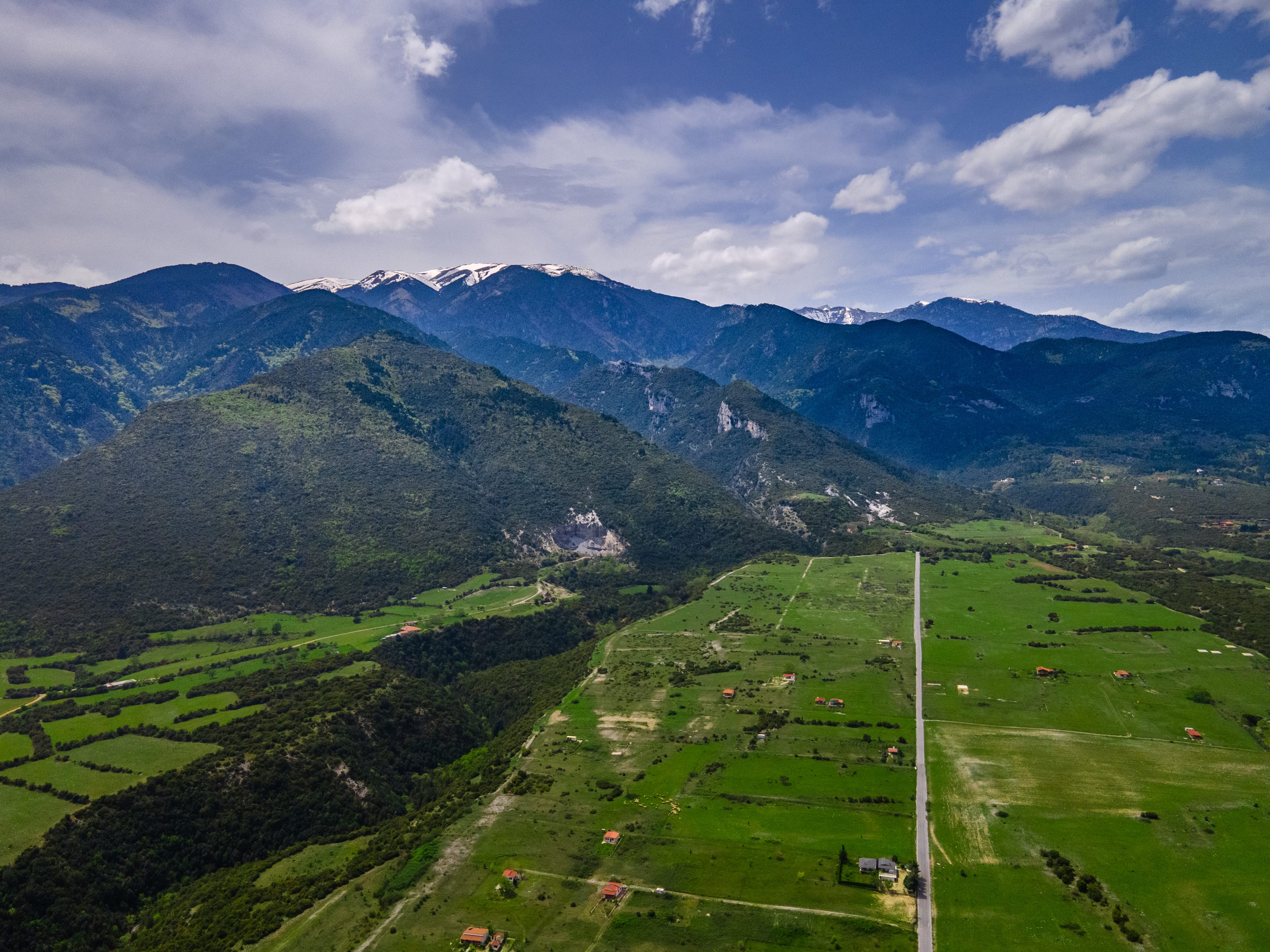 a grassy valley with mountains in the background