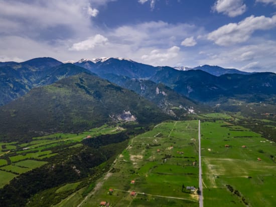 a grassy valley with mountains in the background