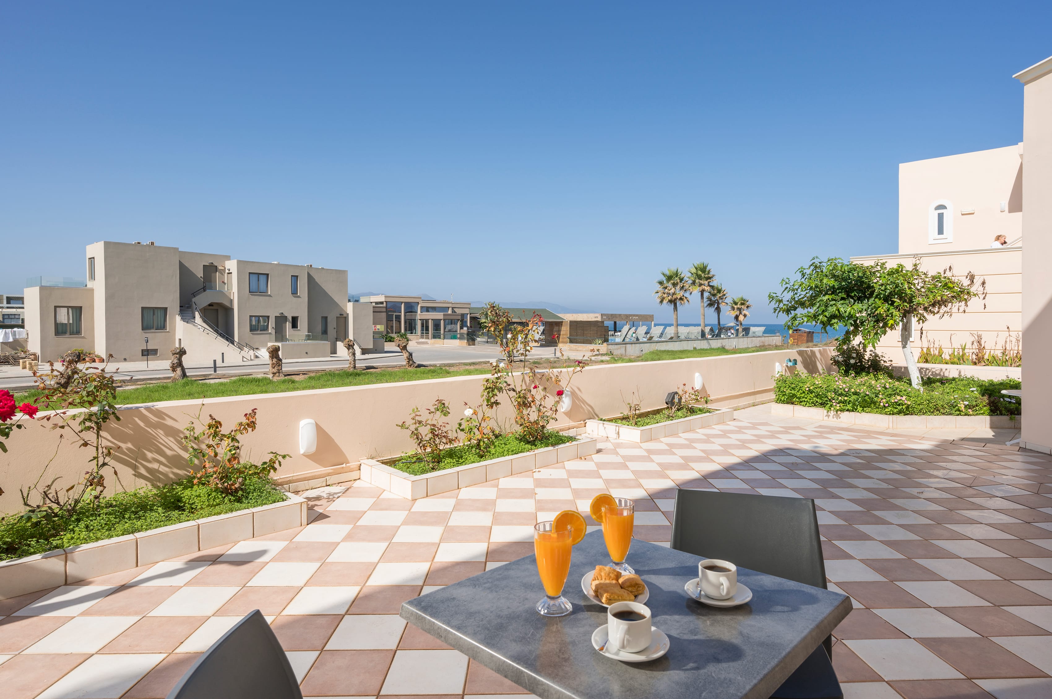 a table with a glass and a glass on it with a view of a beach and buildings in