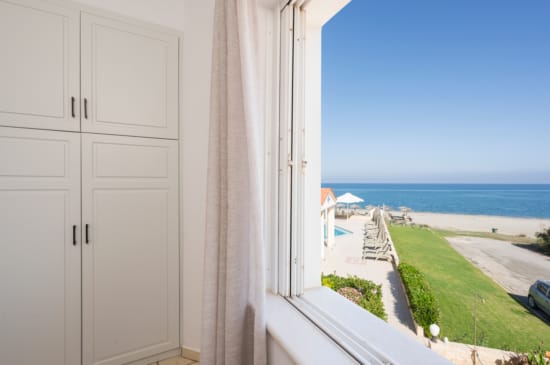 a white door with a view of the ocean and a beach