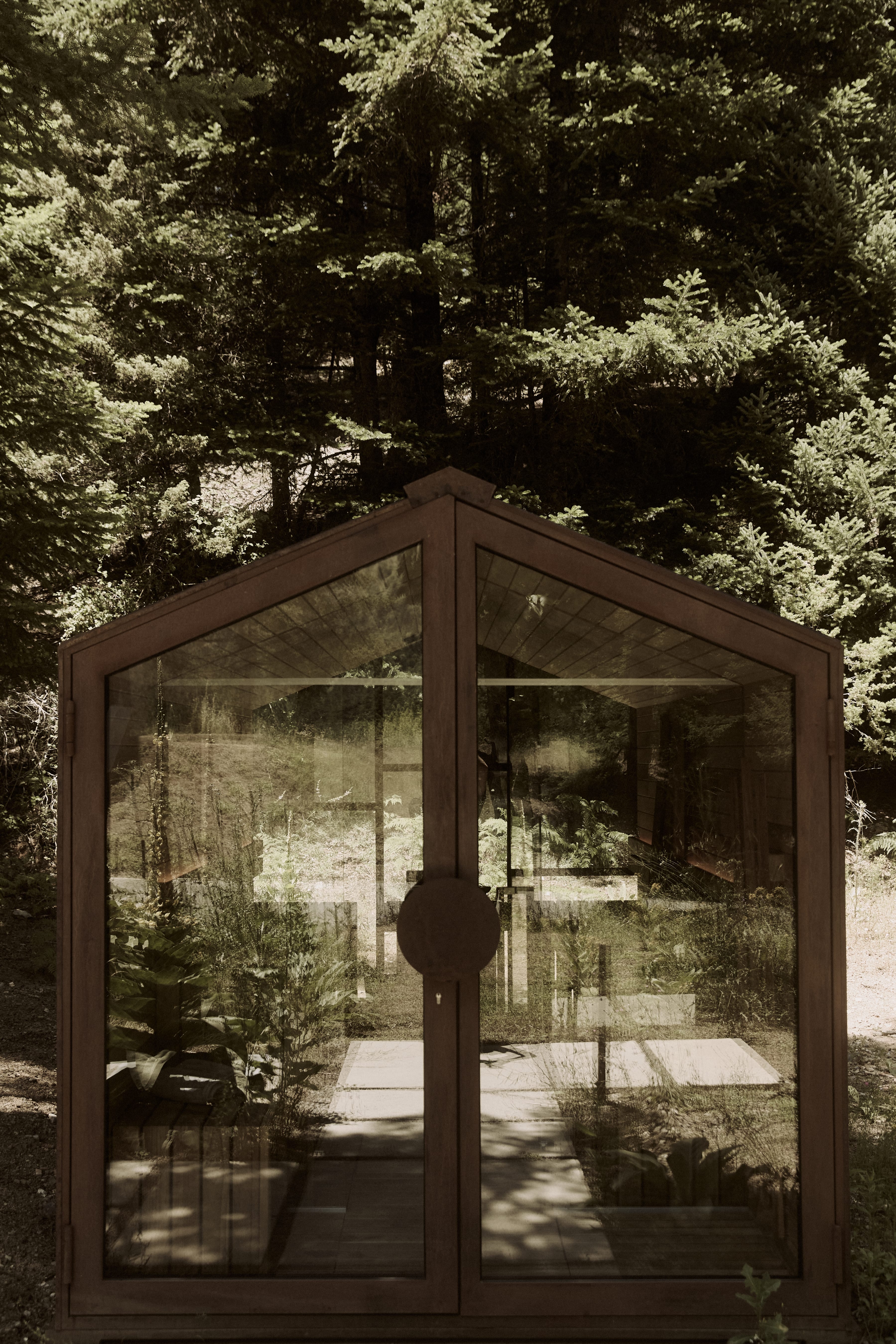 a glass door with a view of trees and a building