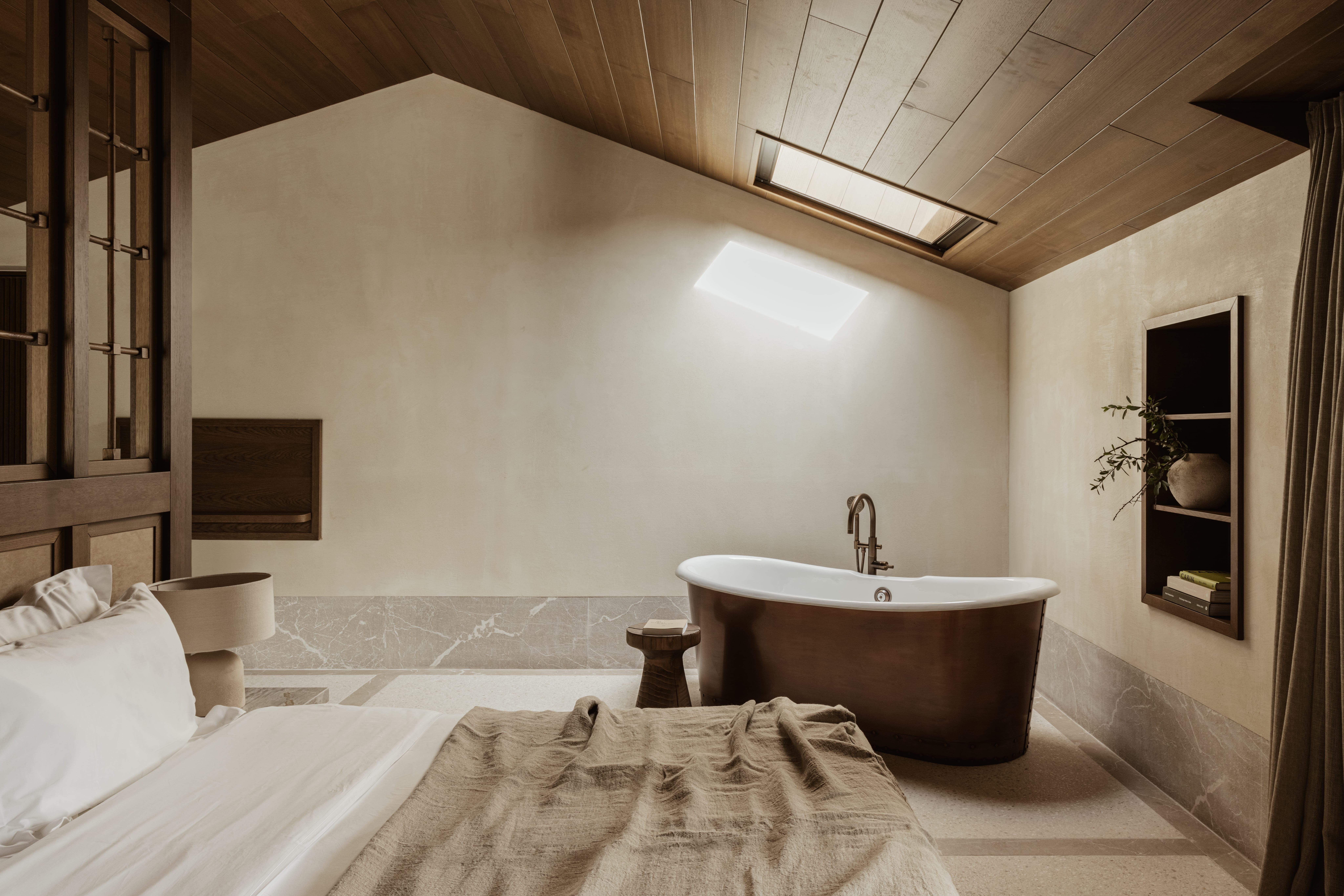 a bathroom with a tub and a bed