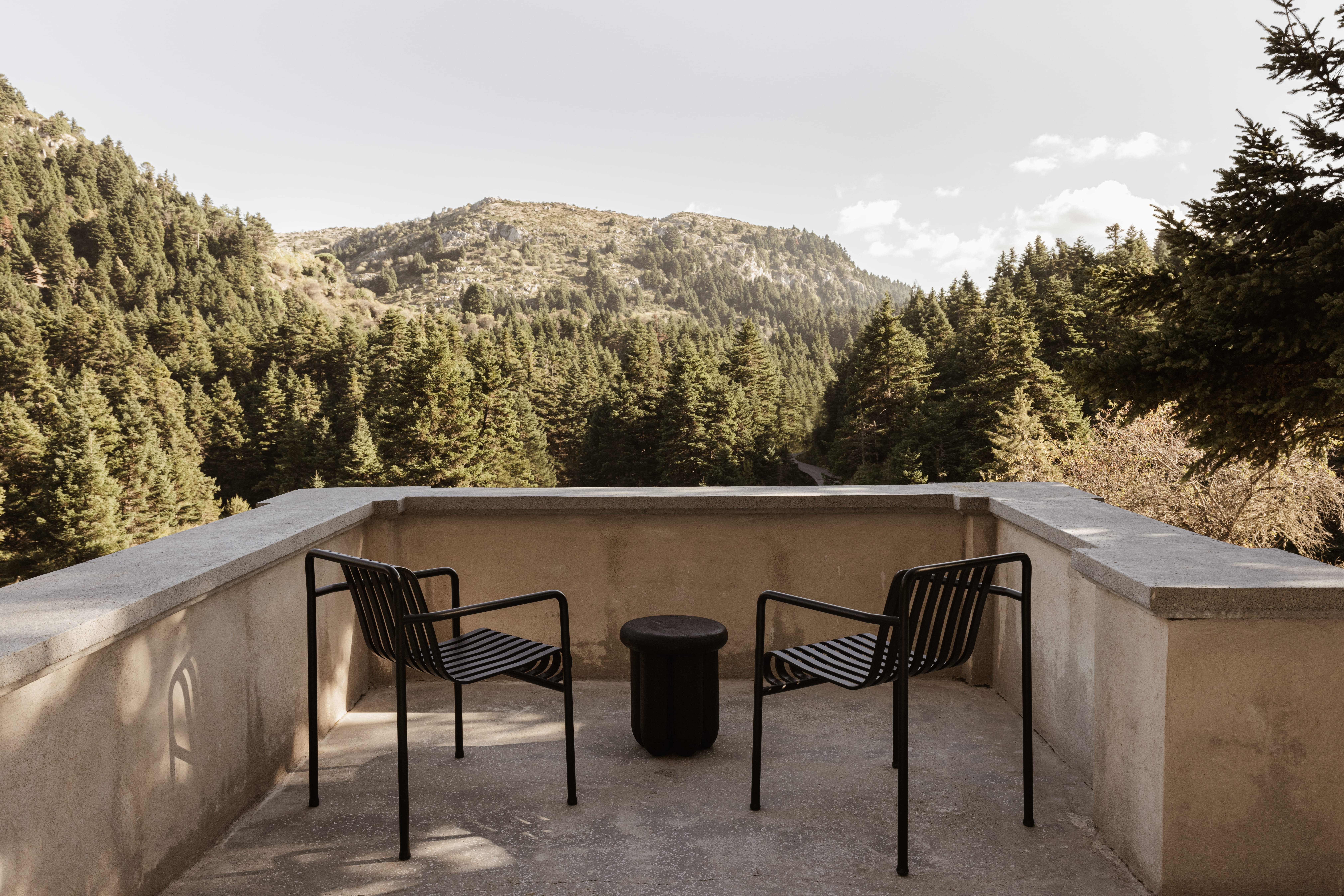 a bench and a trash can on a concrete deck