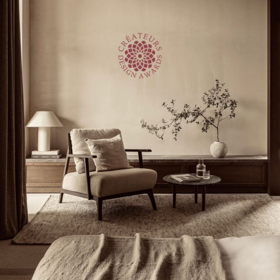 a room with a chair and a table with a plant on it