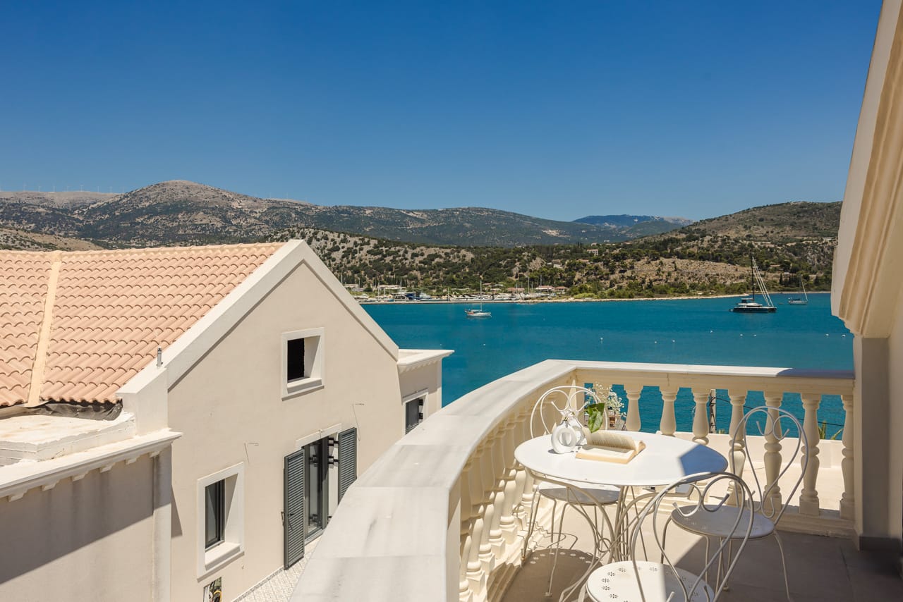 a deck with a table and chairs by a body of water