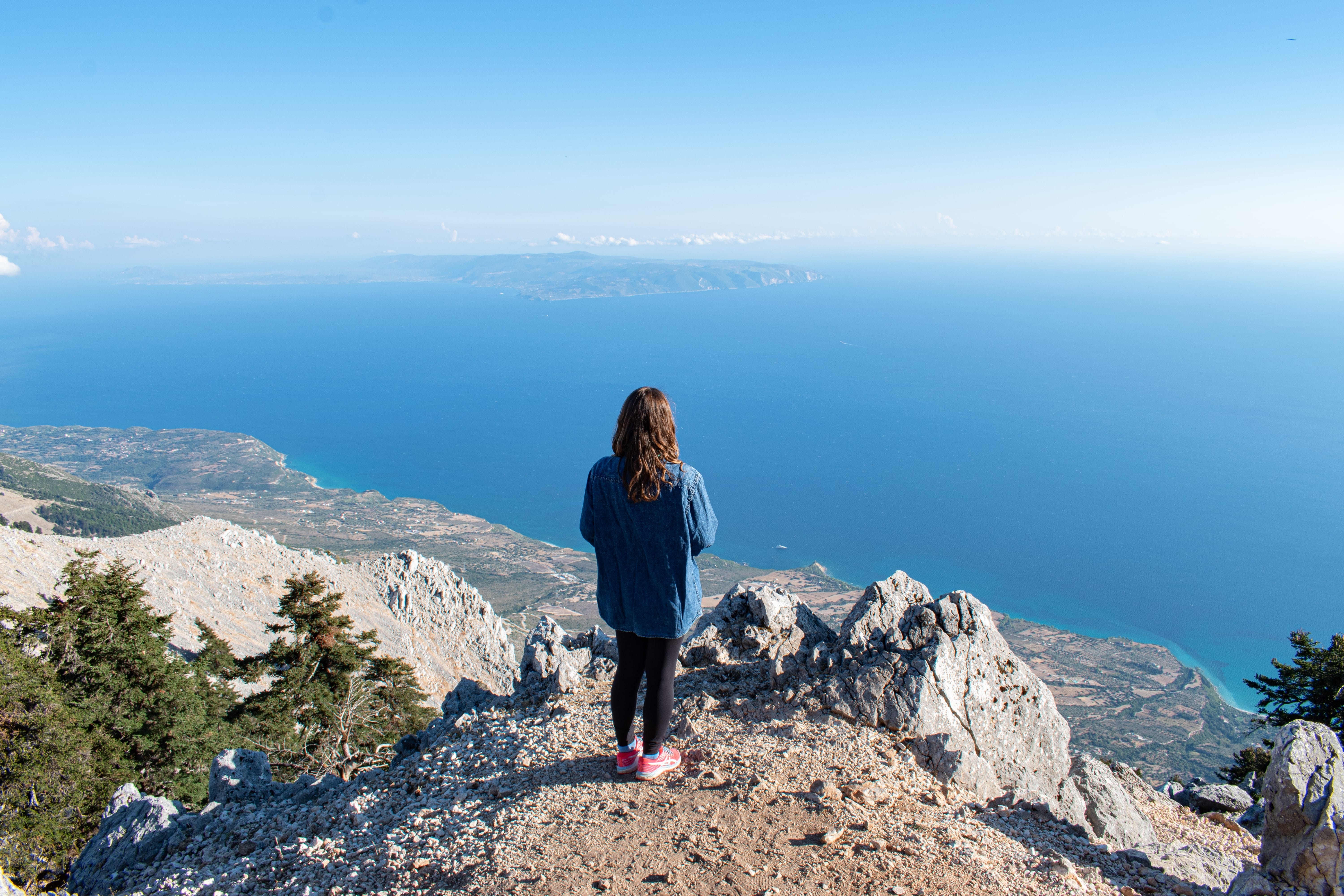 a man standing on a cliff overlooking a body of water