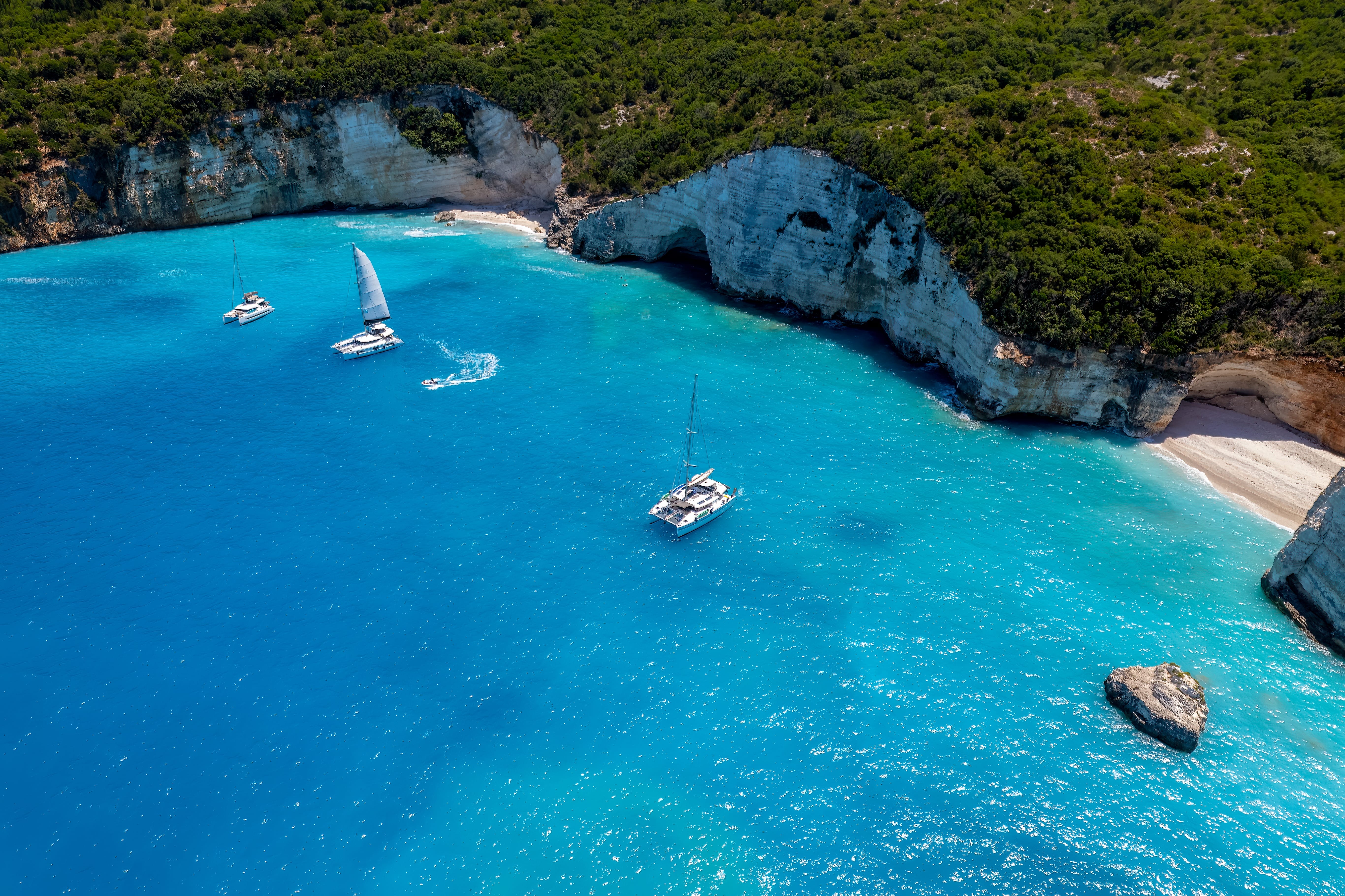 a body of water with boats in it and a rock in the middle