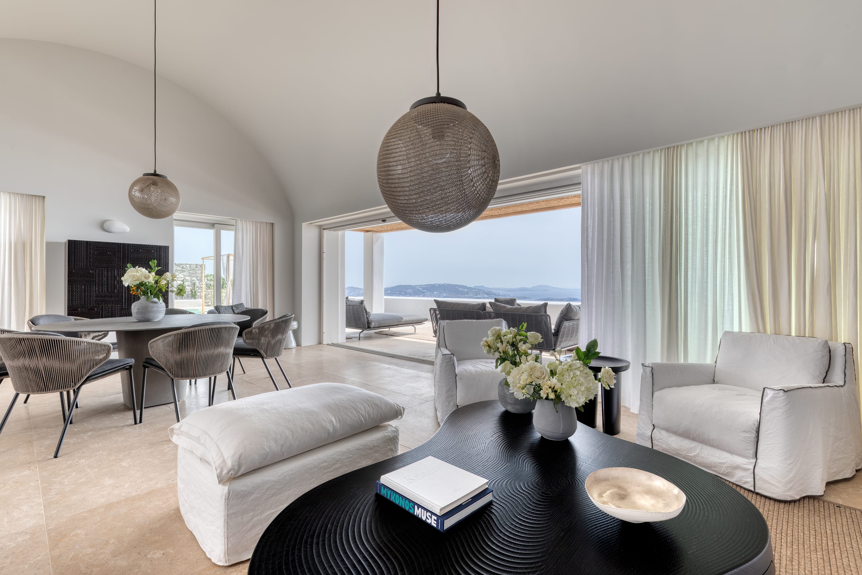a living room with a black table and white couches