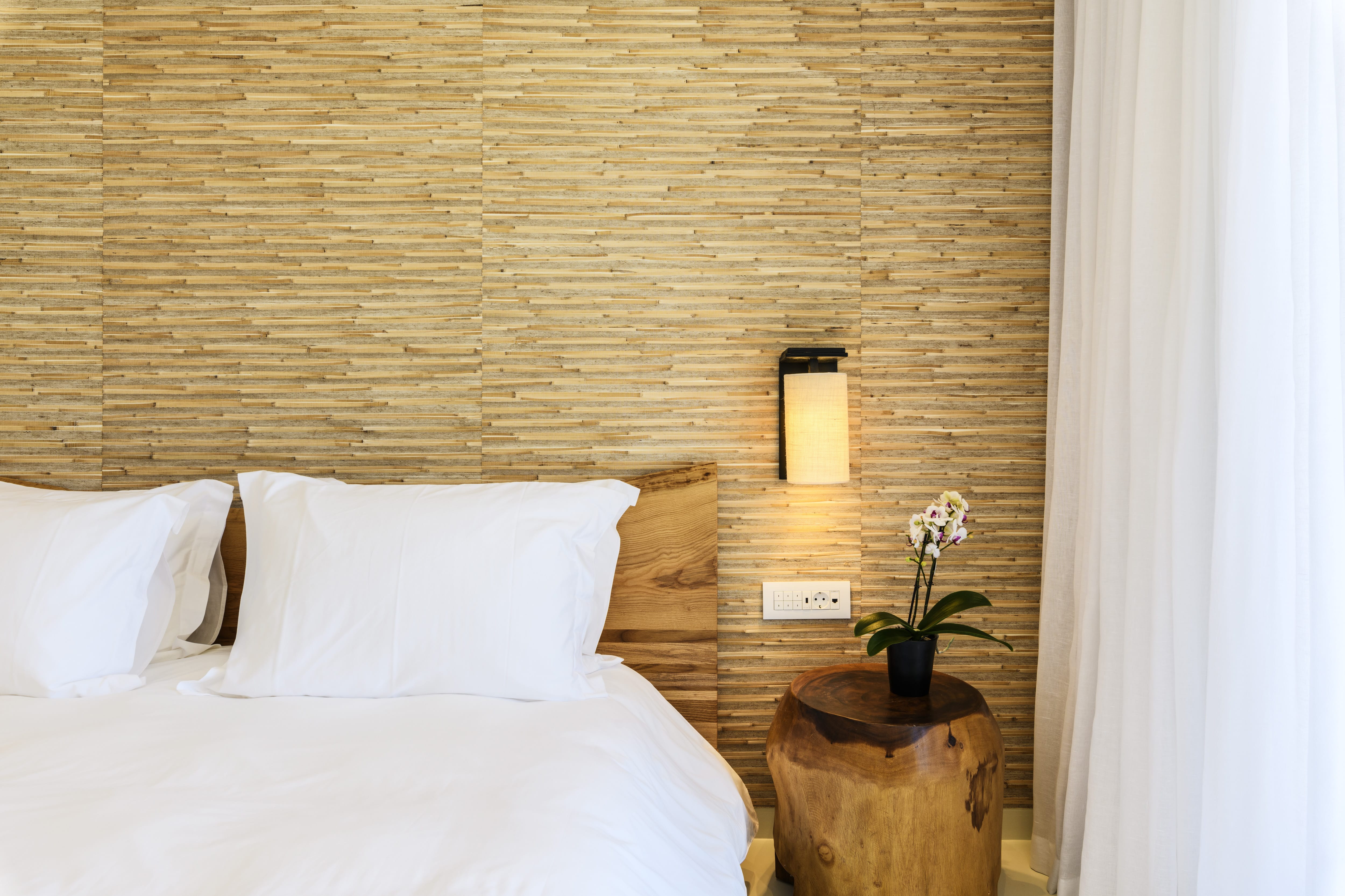 a bed with a lamp and a plant on a table