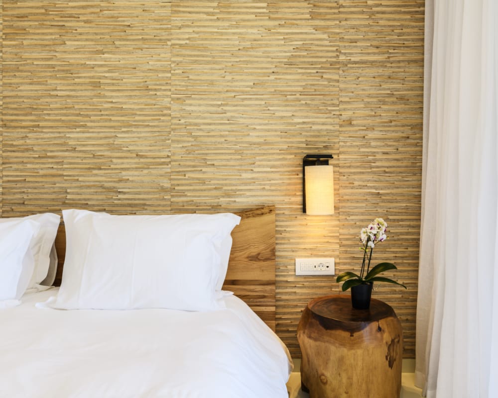 a bed with a lamp and a plant on a table