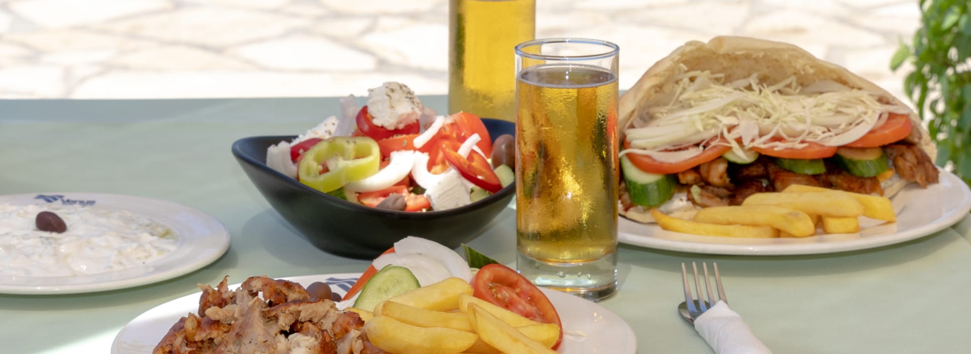 a table with plates of food and glasses of beer