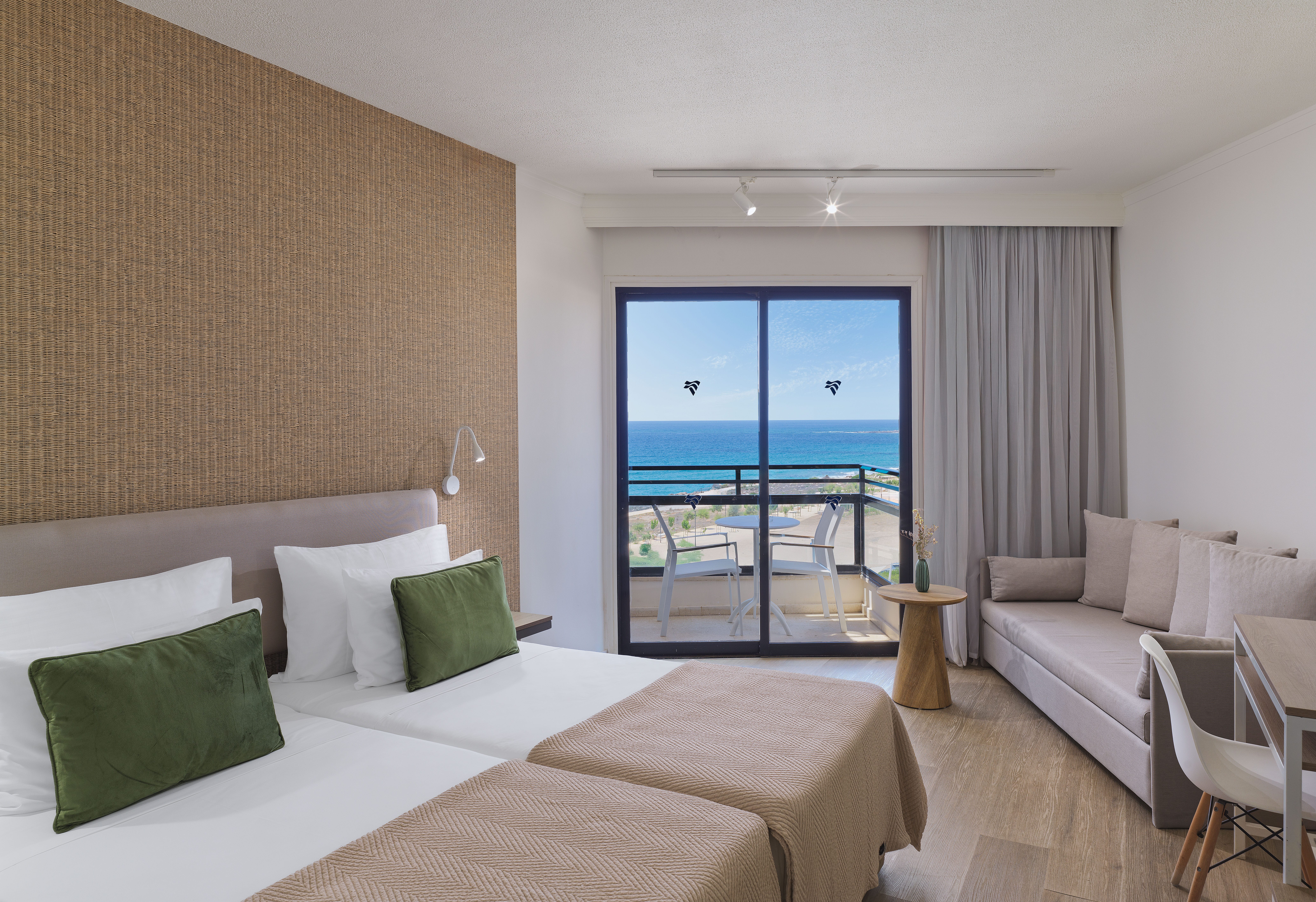 a room with two beds and a window overlooking the ocean