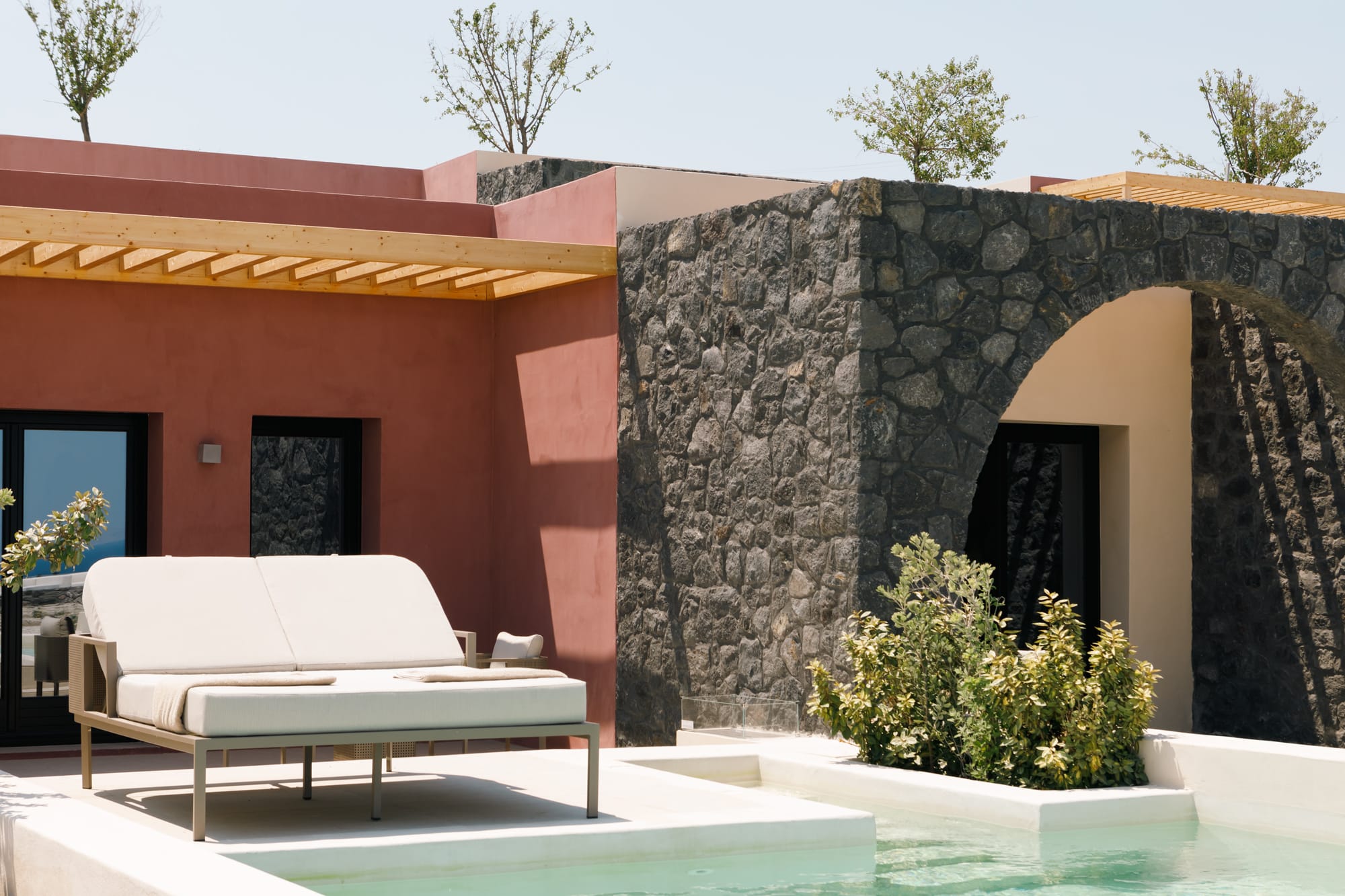 a house with a pool and a large rock wall