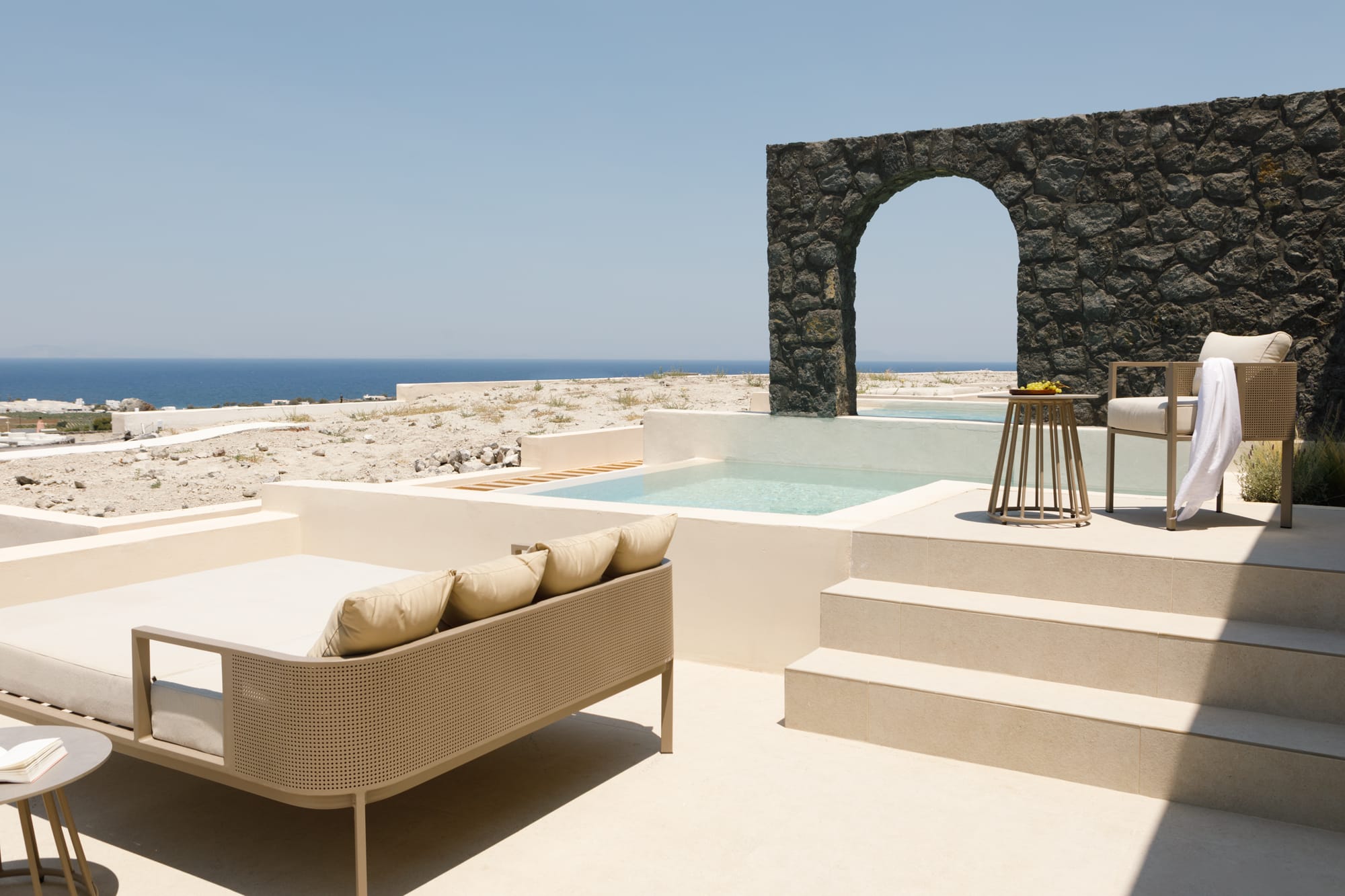 a pool and lounge chairs on a beach