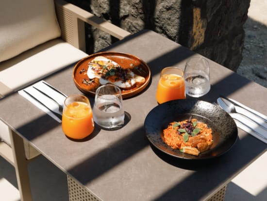 a table with plates of food and glasses of water