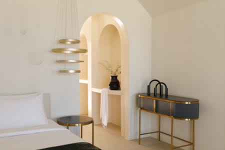 a room with a bed and a shelf with a vase on it