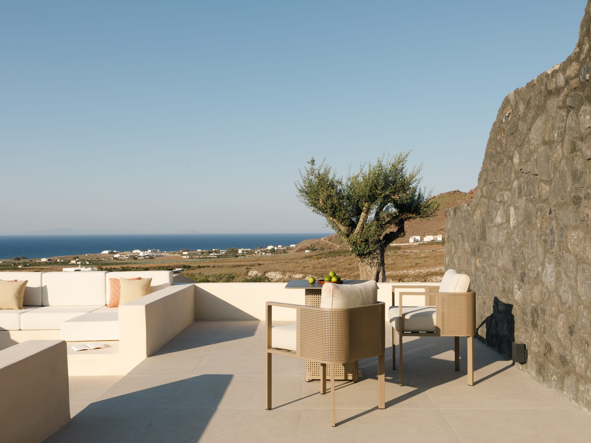 a patio with chairs and a tree