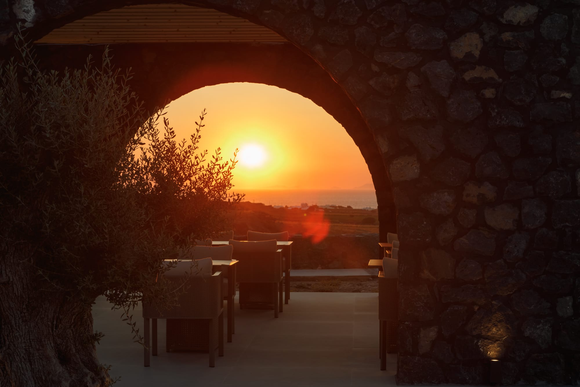 a stone archway with a sunset