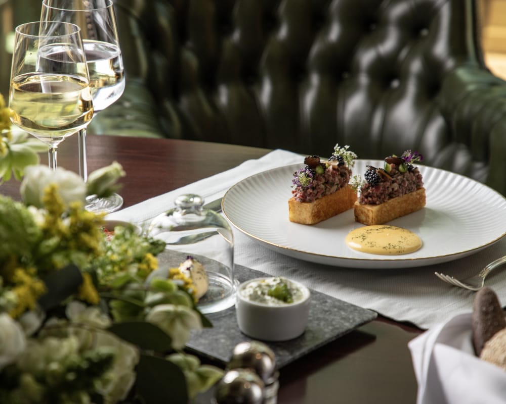a plate of desserts and a glass of wine on a table