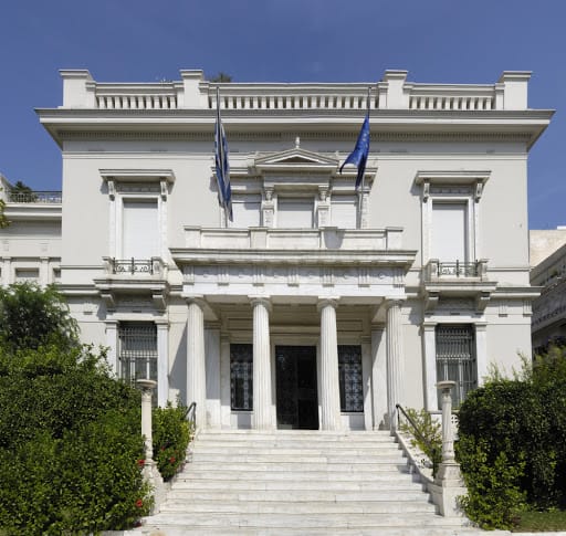 a white building with columns and a flag on the front