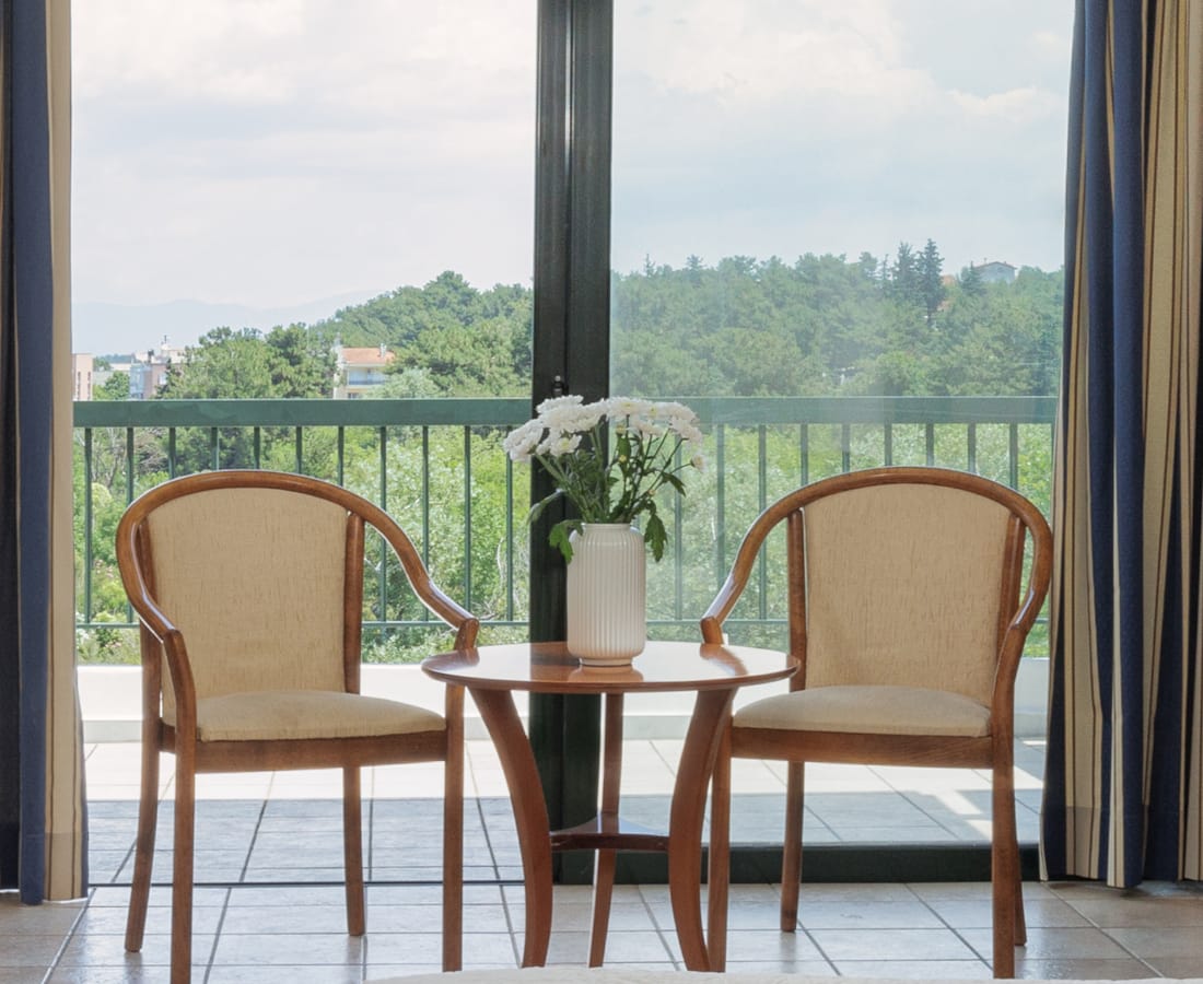 a table and chairs in front of a window with a view of a city