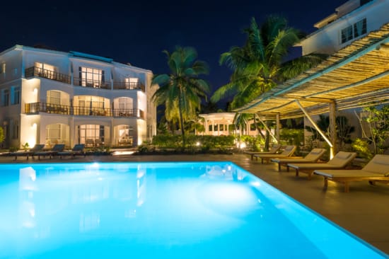 a pool with lounge chairs and a building in the background