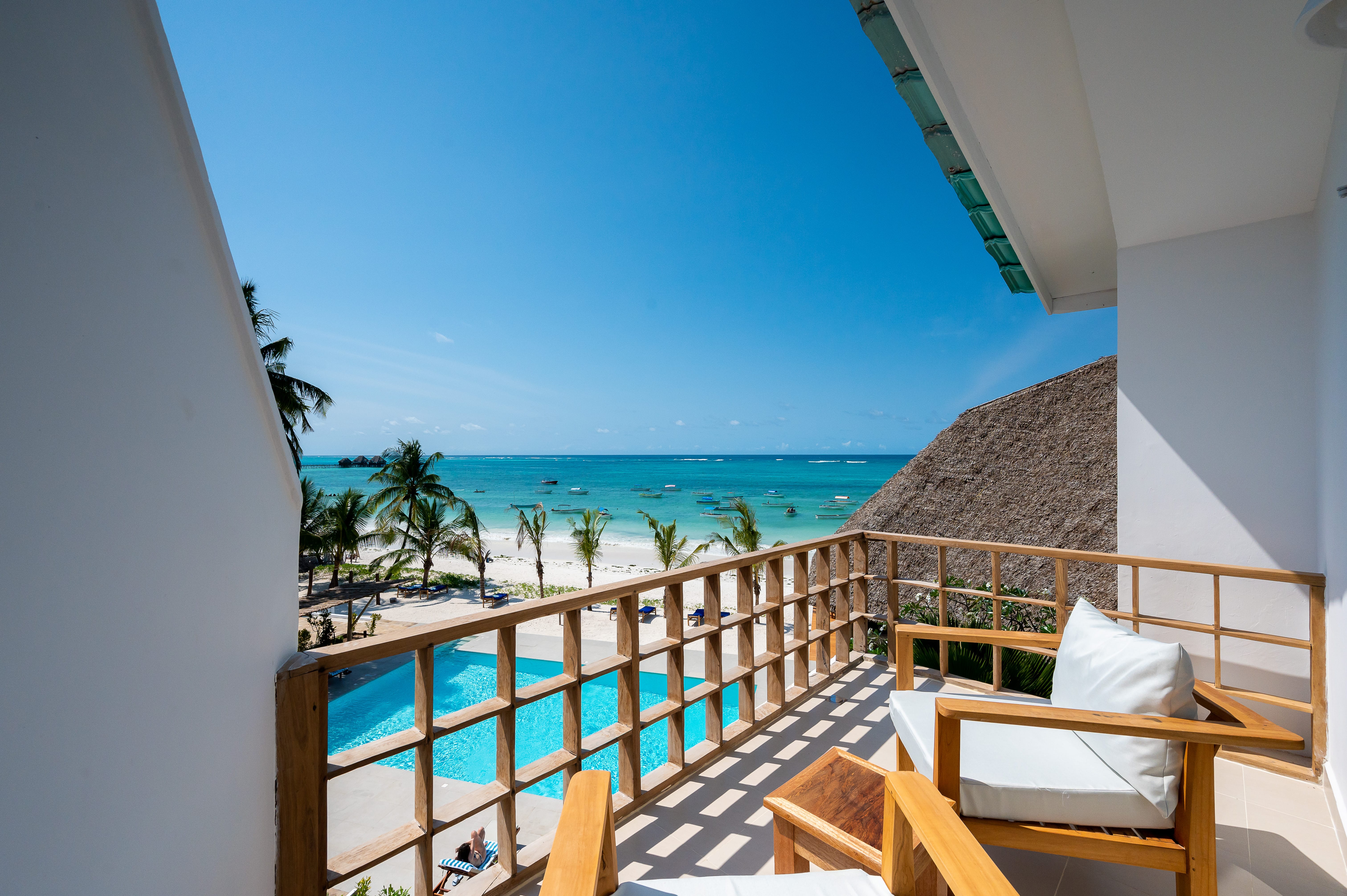 a deck with chairs and a body of water in the background