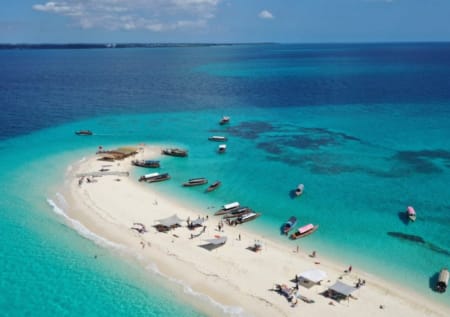a beach with boats and people
