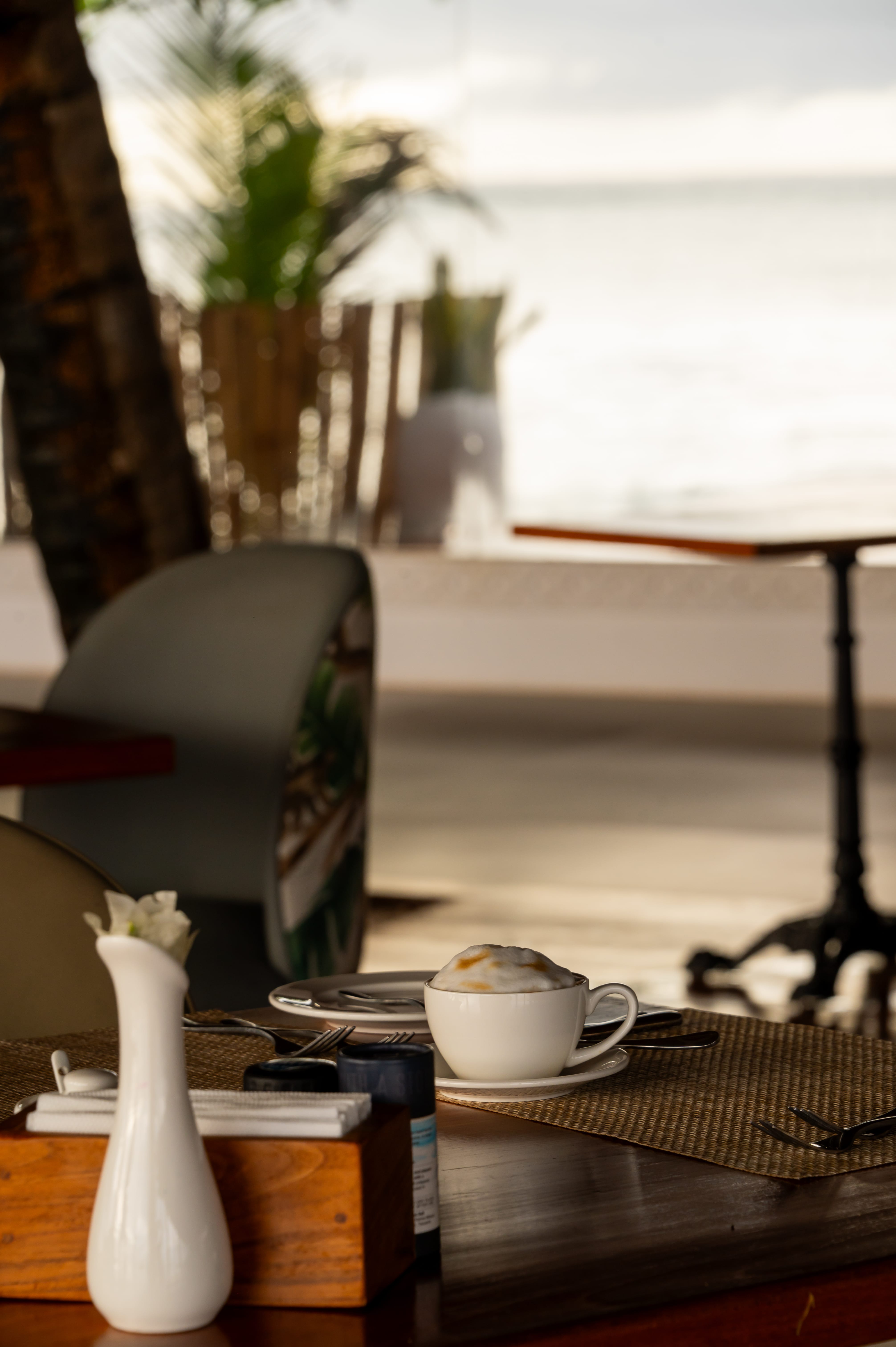 a table with a vase and a cup of coffee on it
