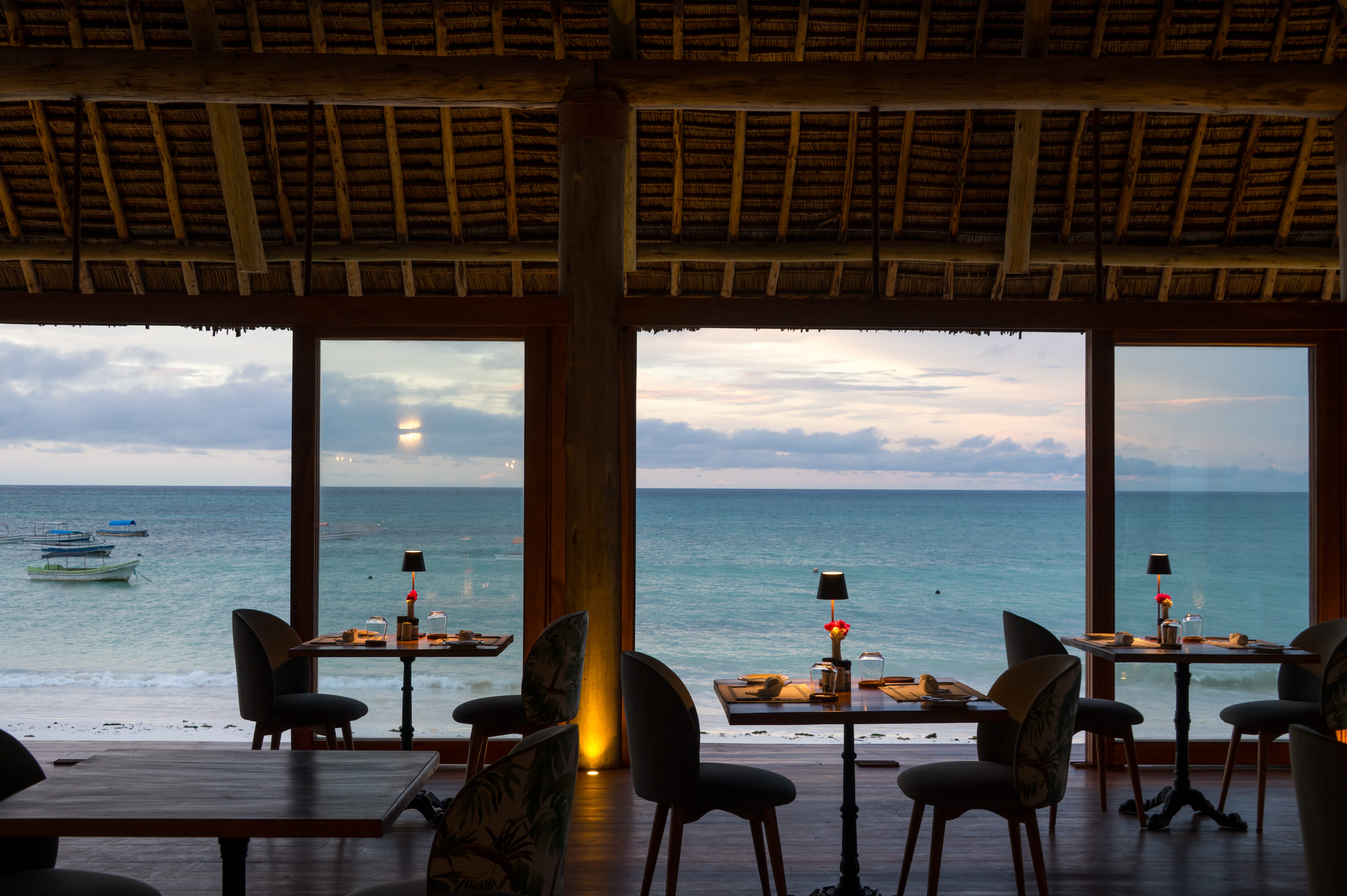 a group of tables and chairs next to a body of water
