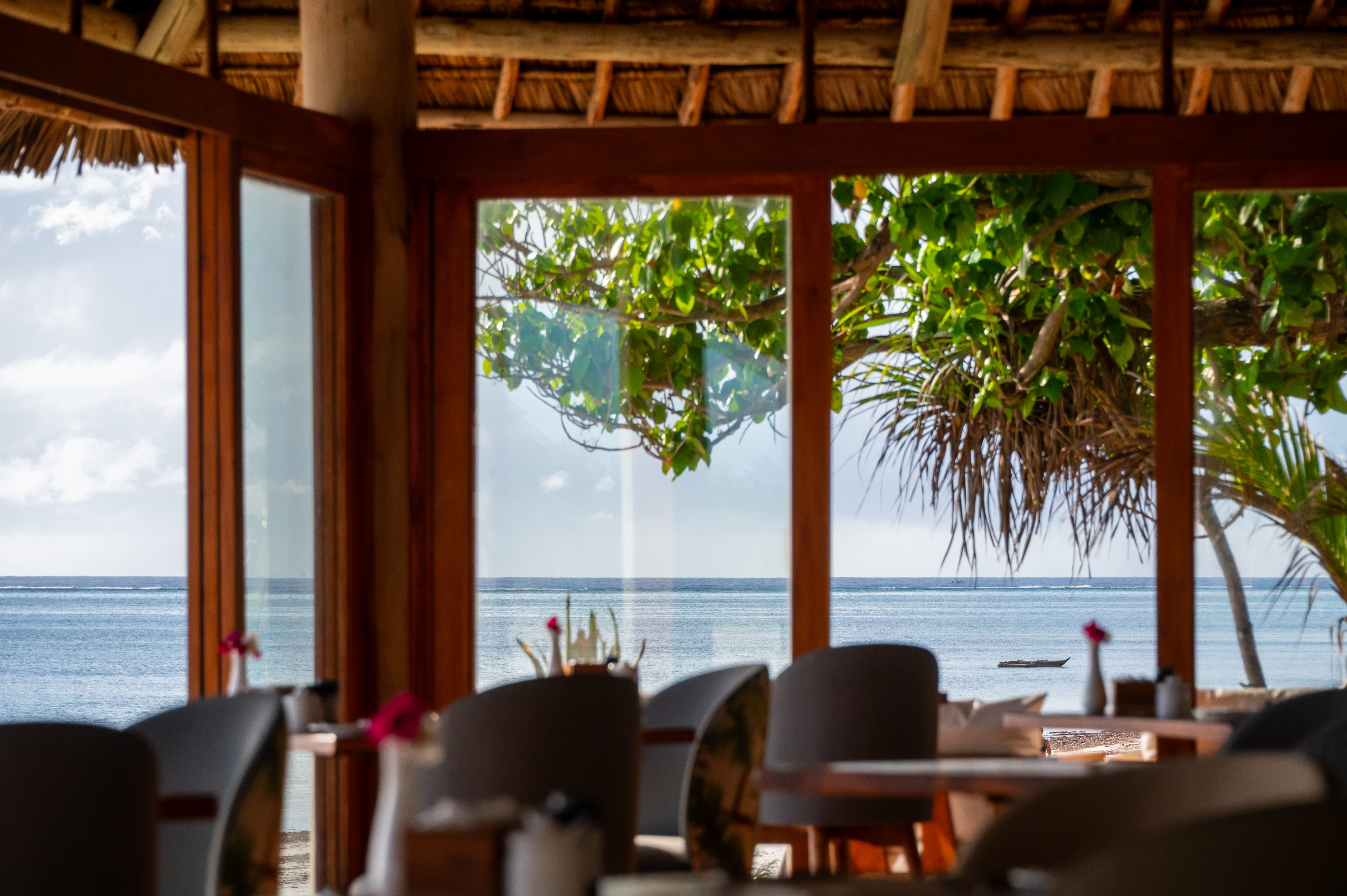 a room with tables and chairs and a large body of water