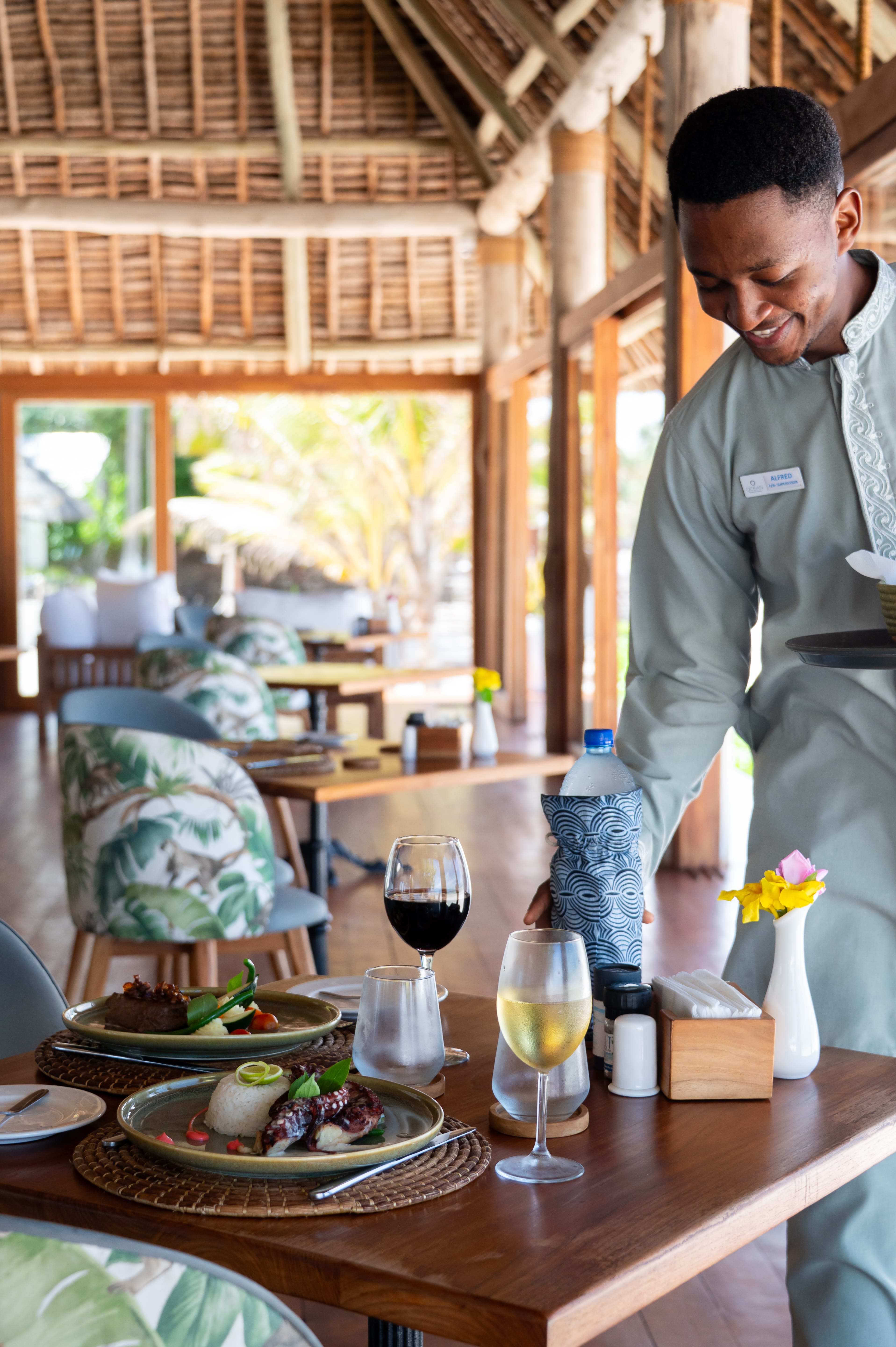 a man standing next to a table with food and drinks