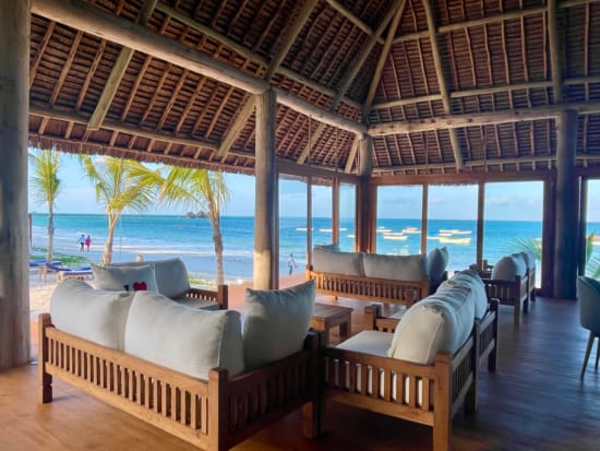 a room with chairs and a table with a view of the ocean