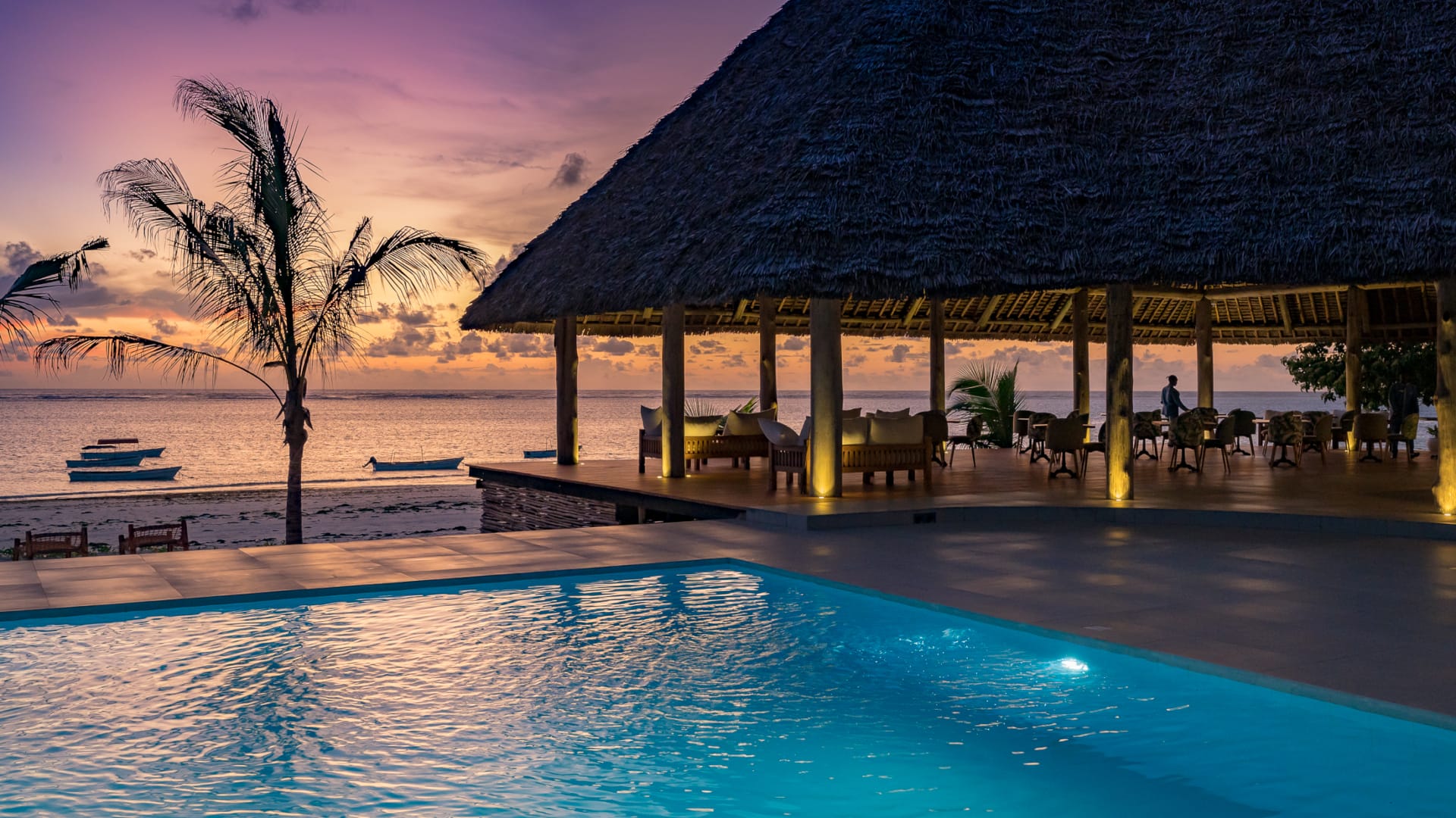 a pool with a hut in the background