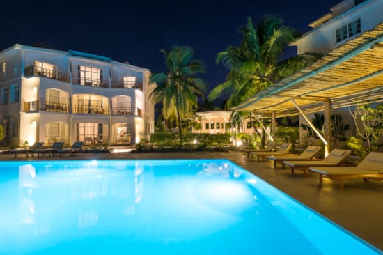a pool with lounge chairs and a building in the background