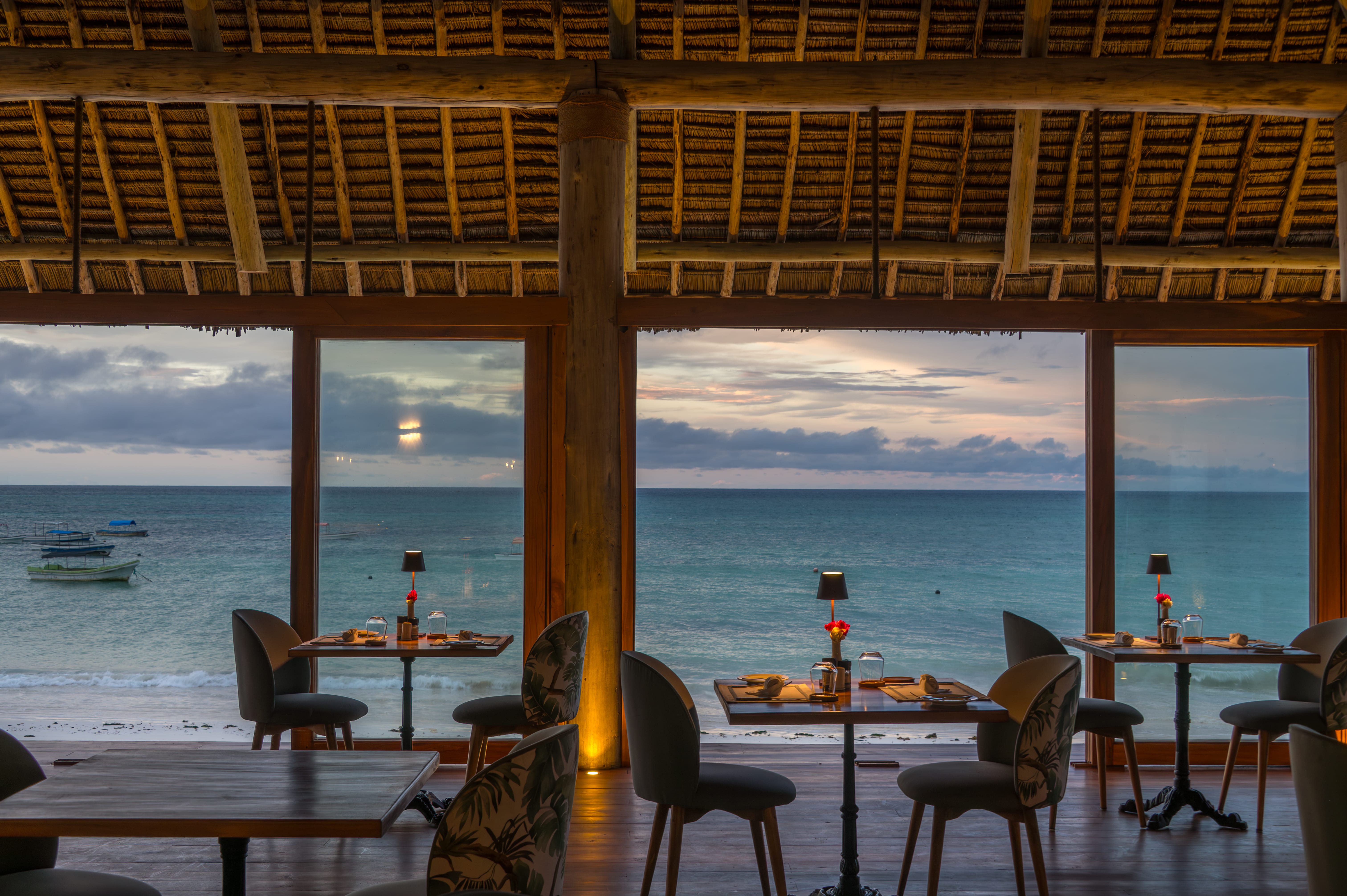 a group of tables and chairs next to a body of water