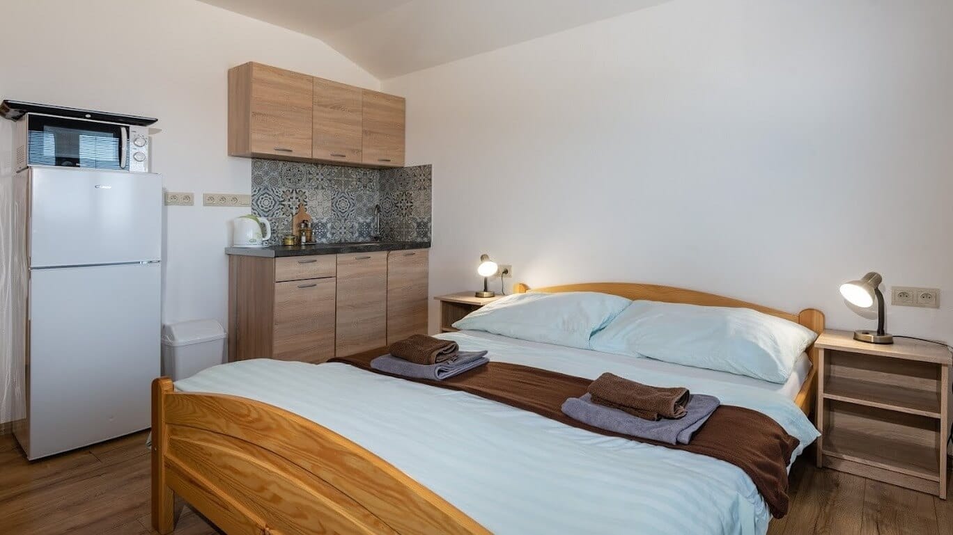 a bedroom with a bed and a refrigerator