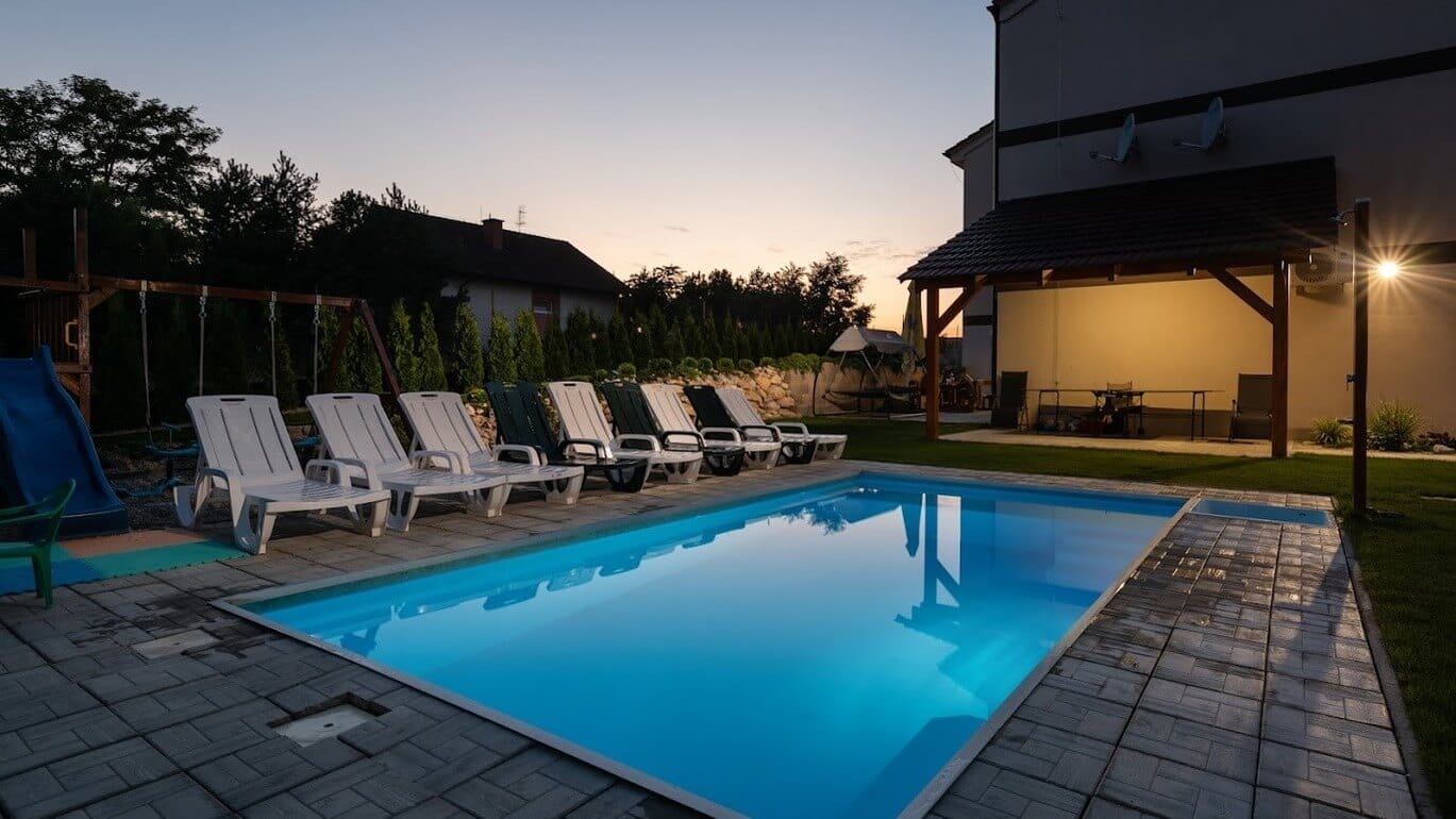 a swimming pool with chairs around it