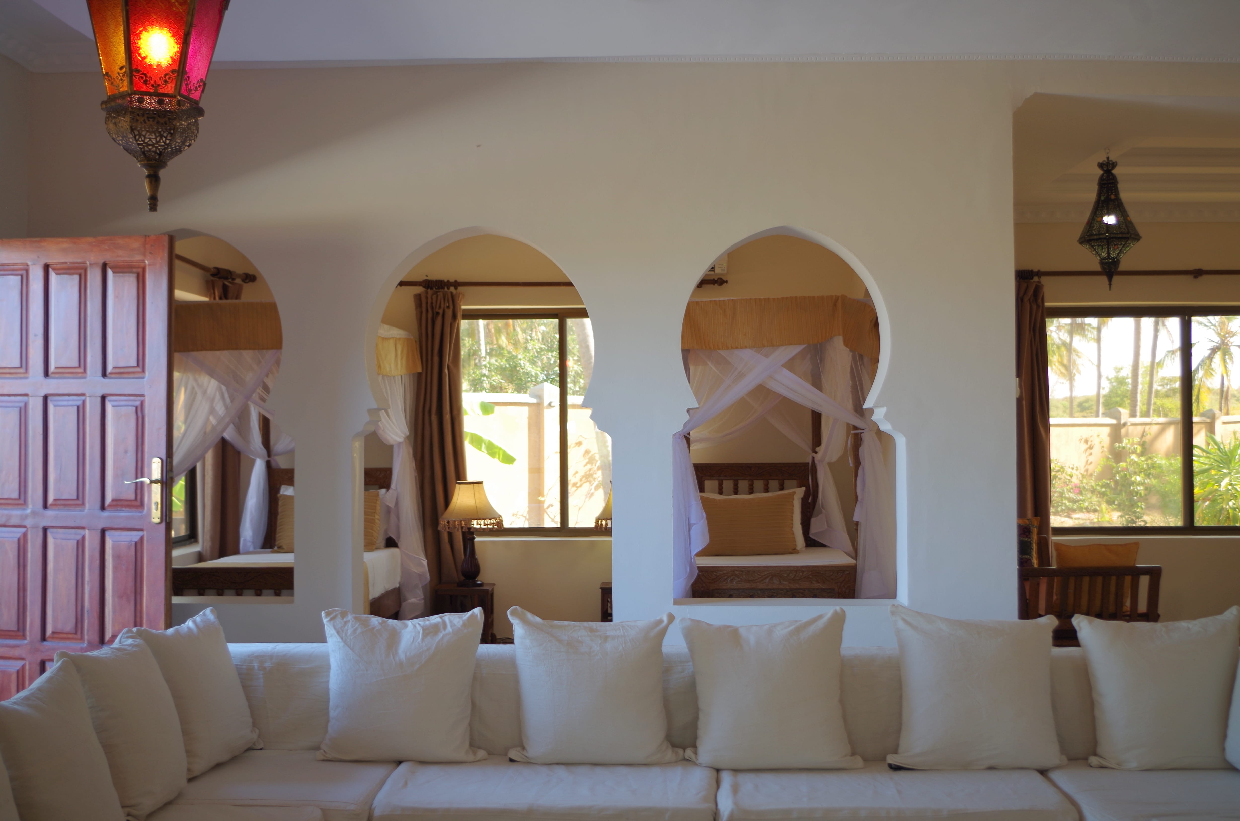 a room with white couches and a large mirror