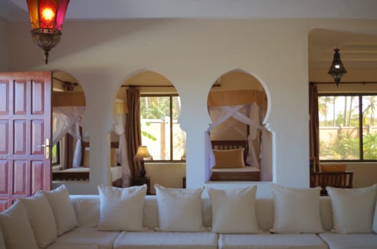 a room with white couches and a large mirror