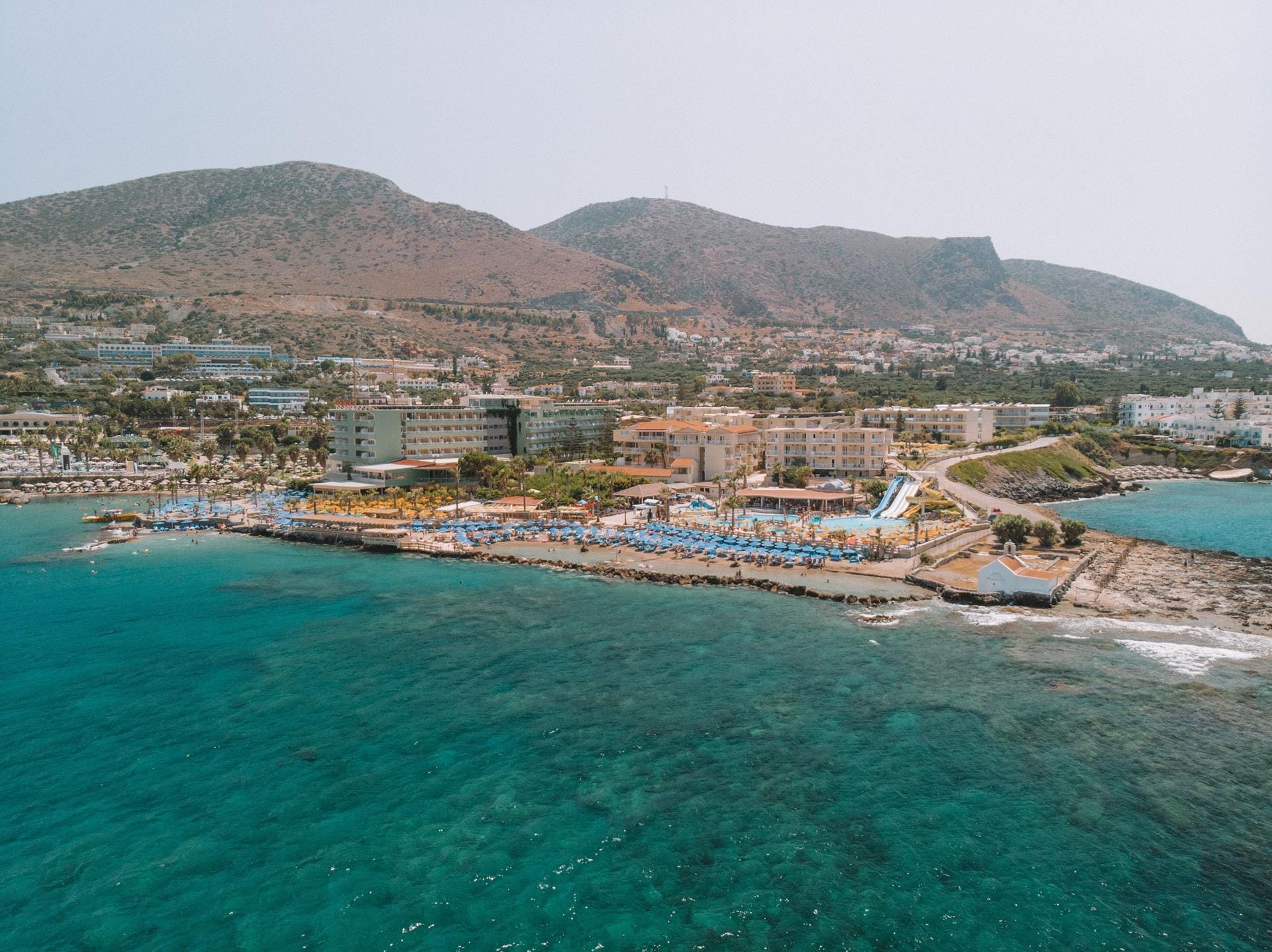a body of water with buildings and mountains