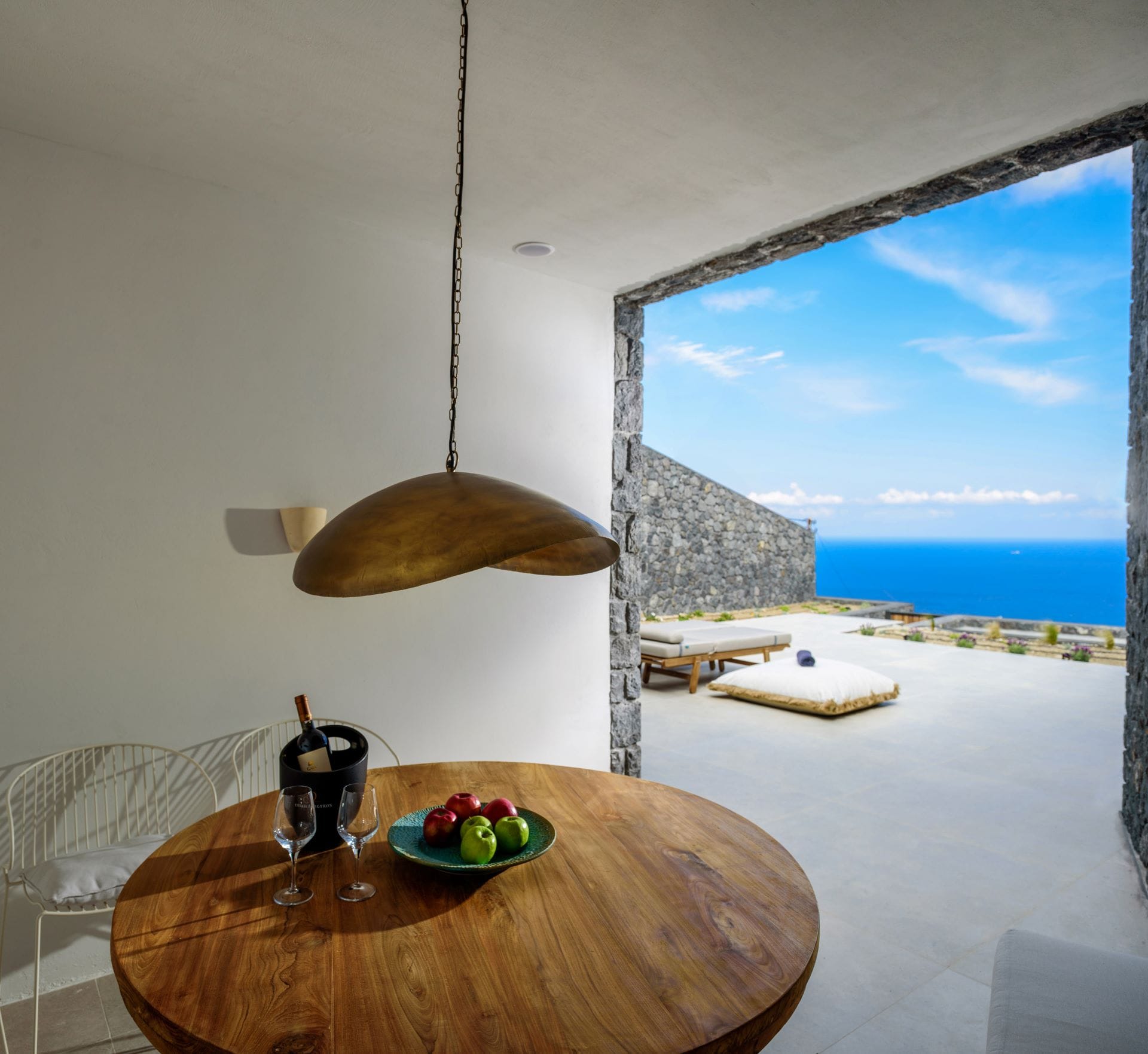 a table with a lamp and a window with a view of the ocean