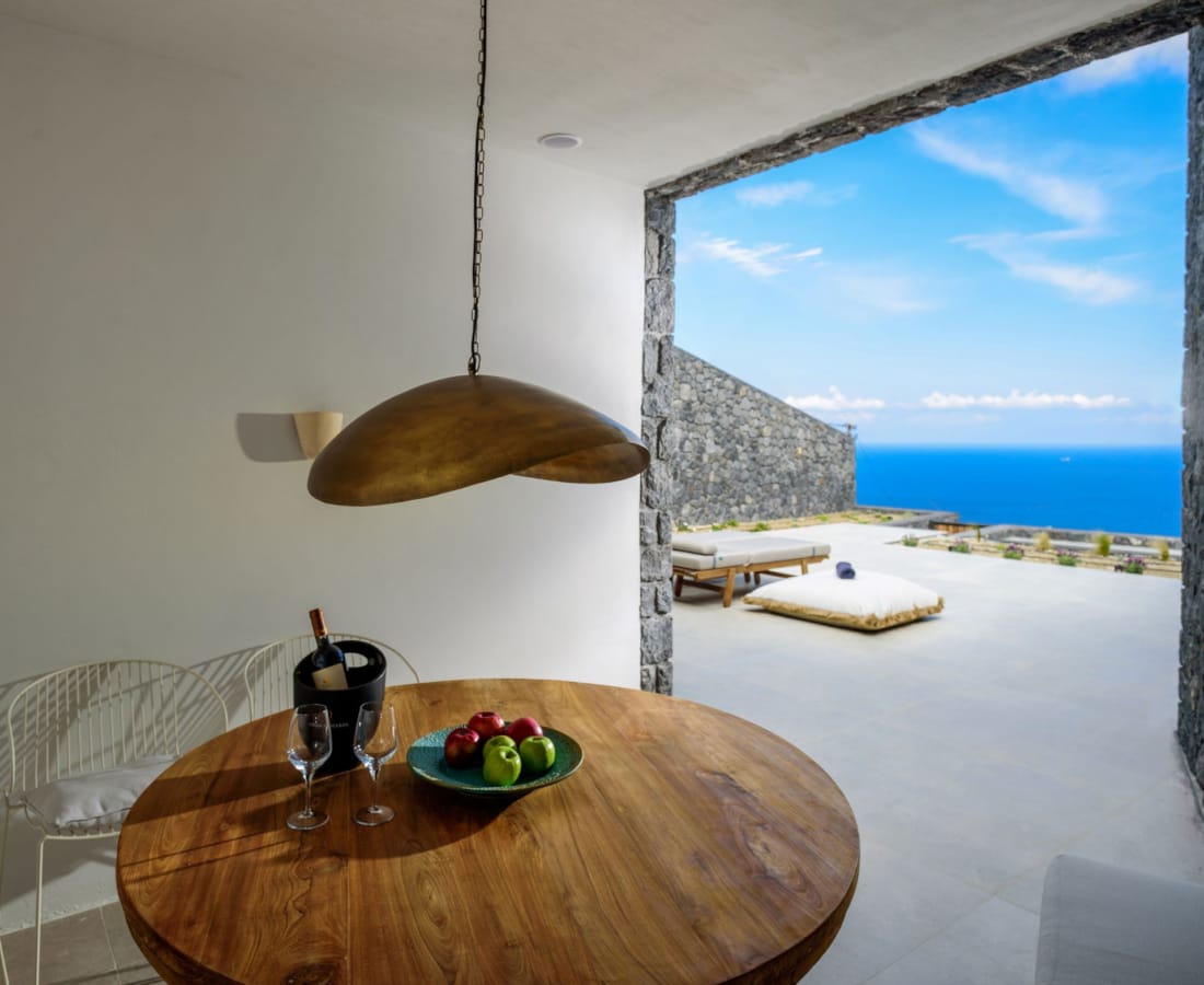 a table with a lamp and a window with a view of the ocean
