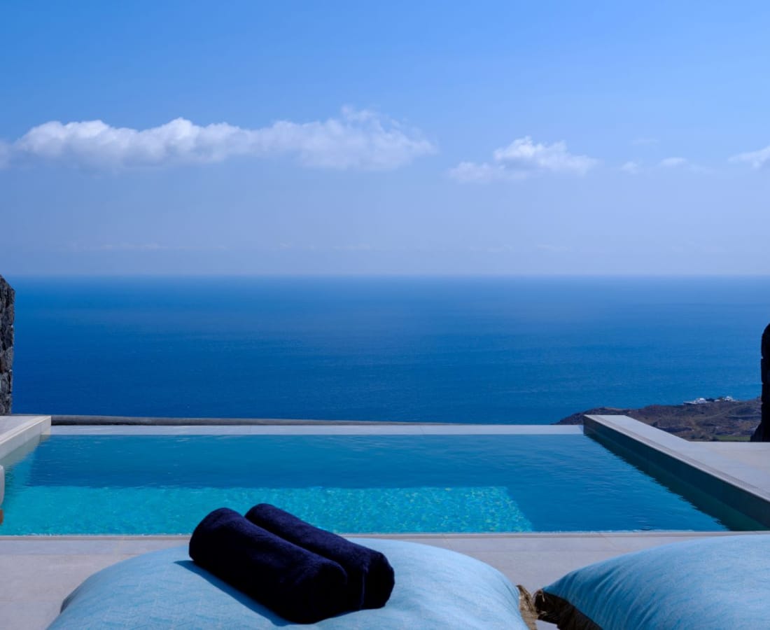 a pool with a rock wall and a blue sky